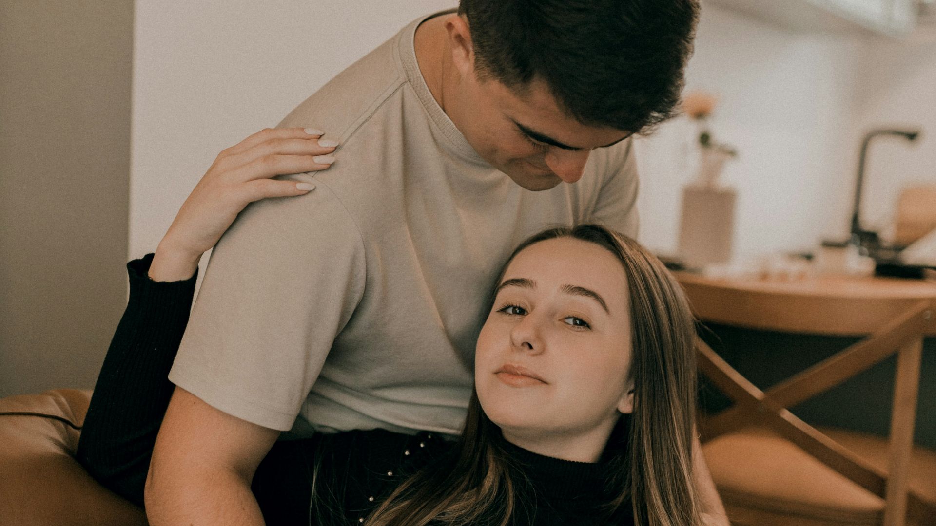 A man sitting on top of a woman on a couch