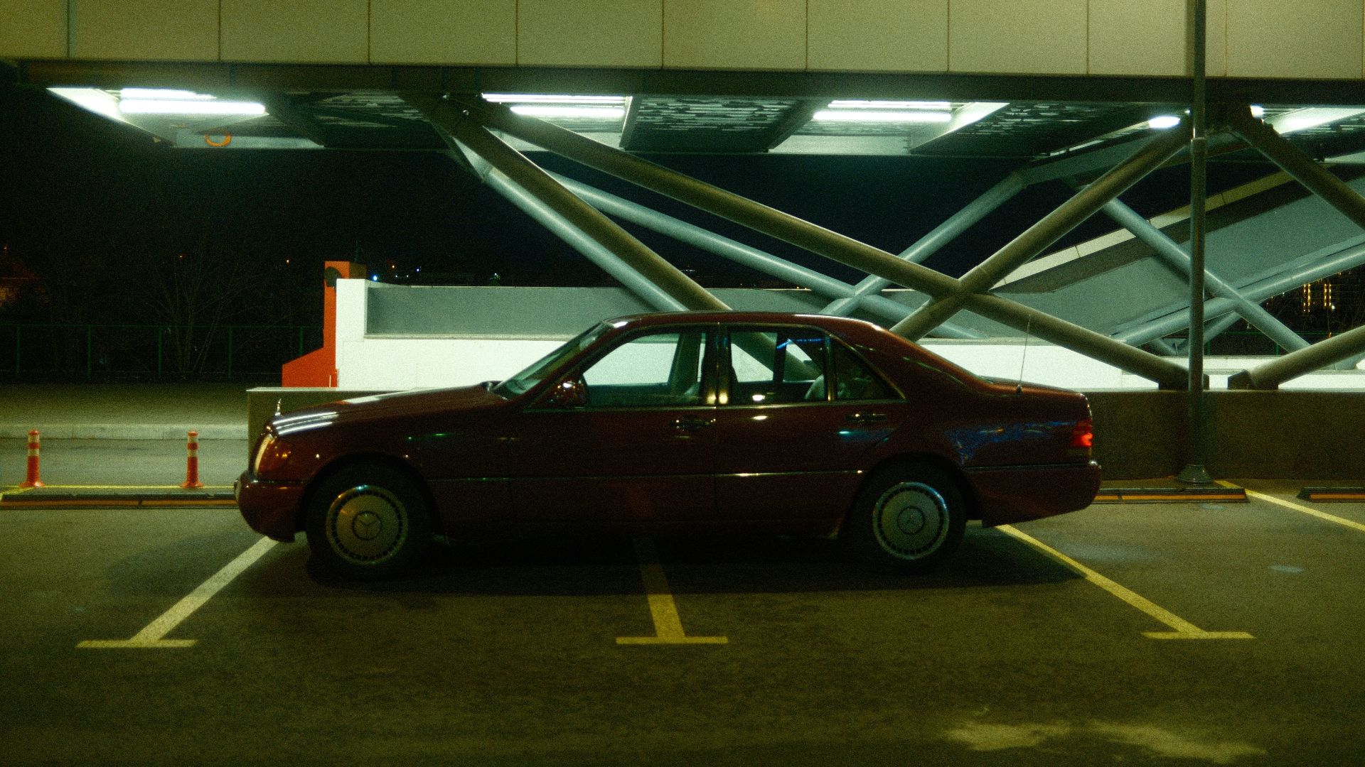 A red car is parked in a parking lot