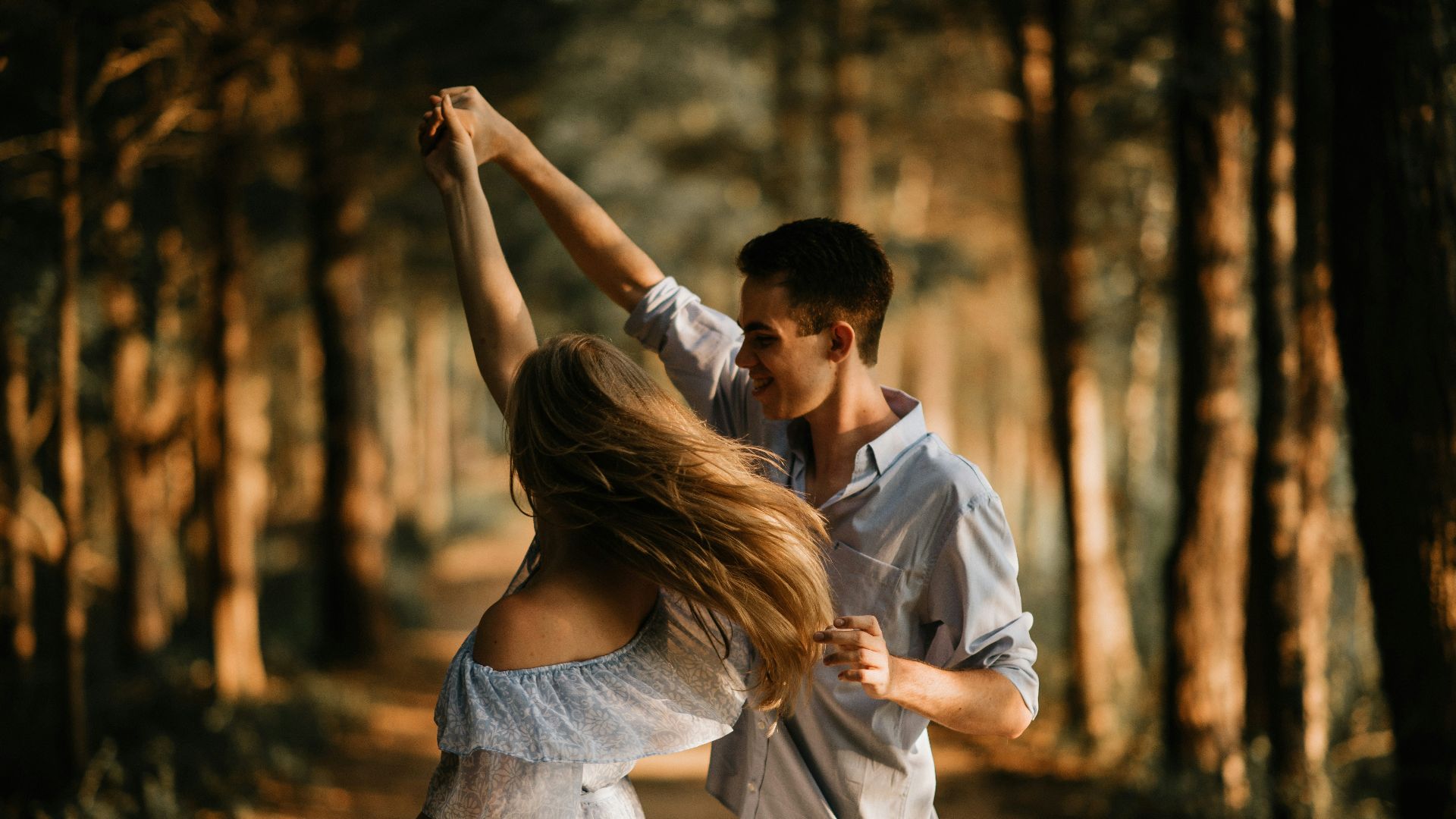 man and woman dancing at center of trees
