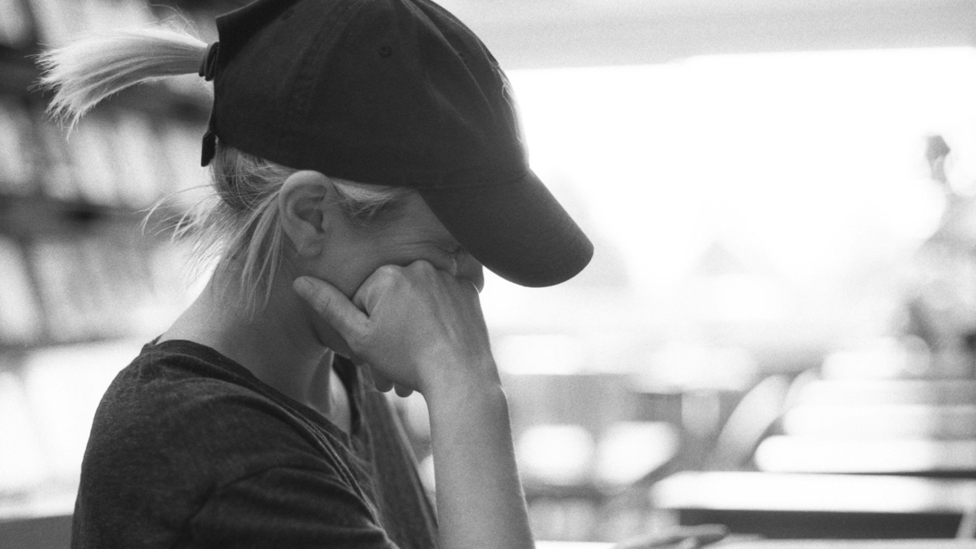 woman in black shirt wearing black hat sitting by the table