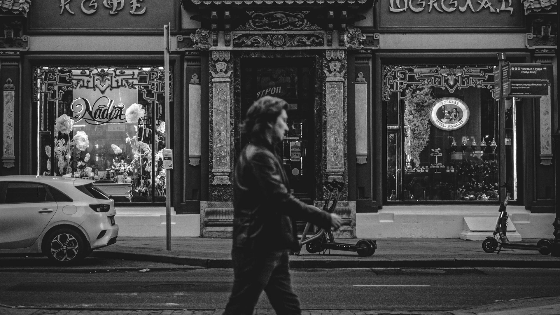 a person walking down a street in front of a building