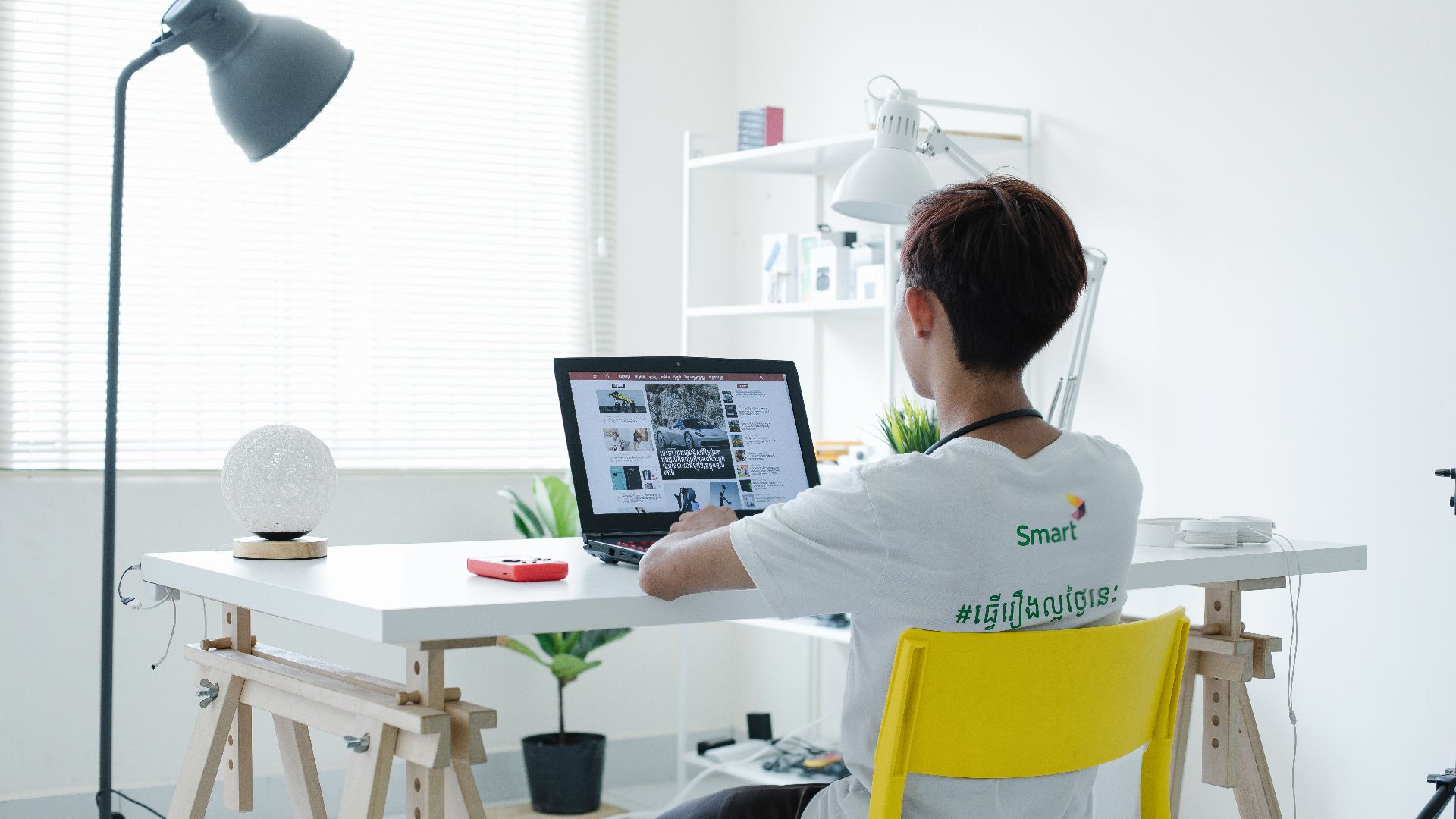 woman in white shirt sitting on chair using laptop computer