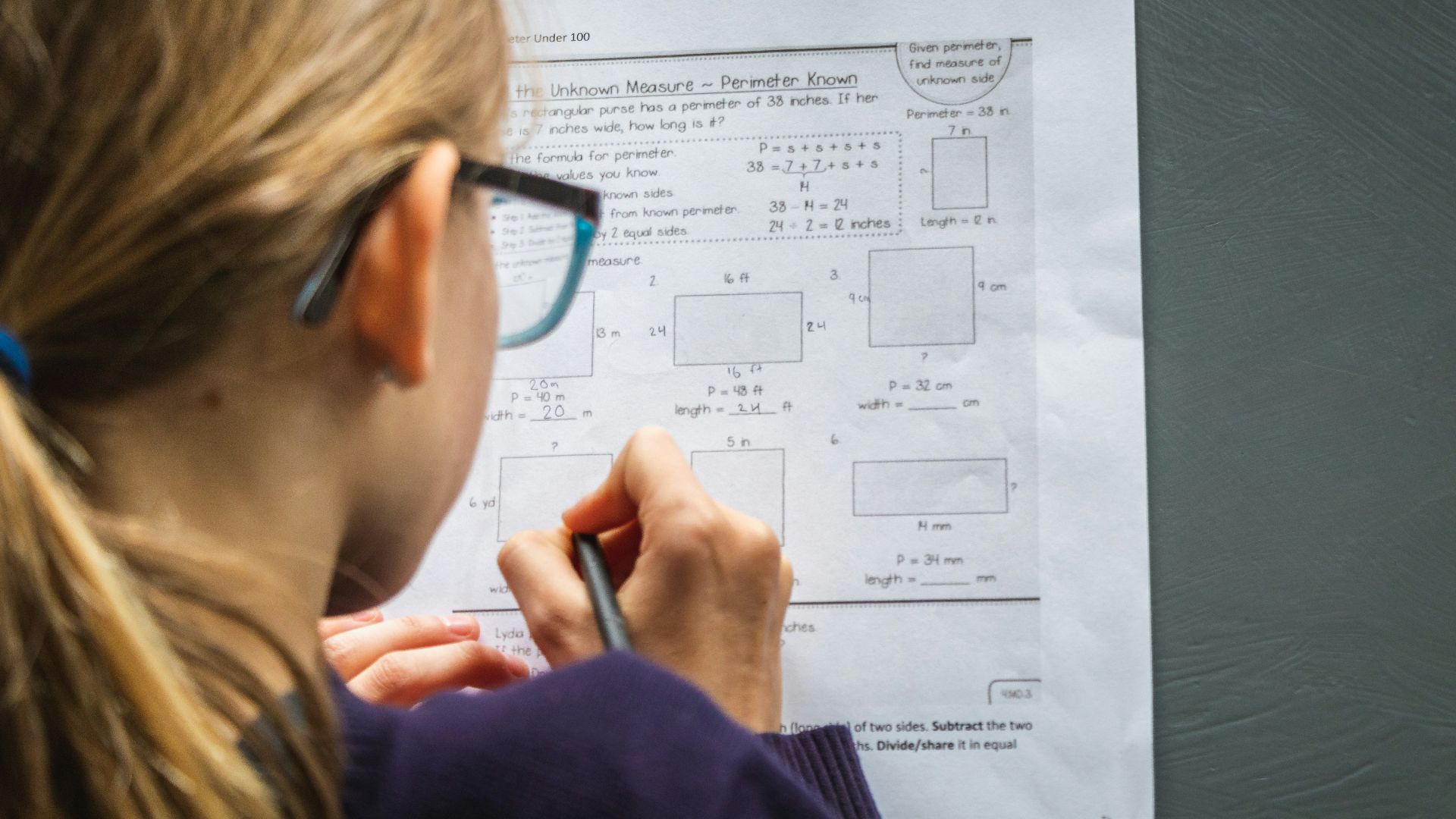 woman in black framed eyeglasses holding pen