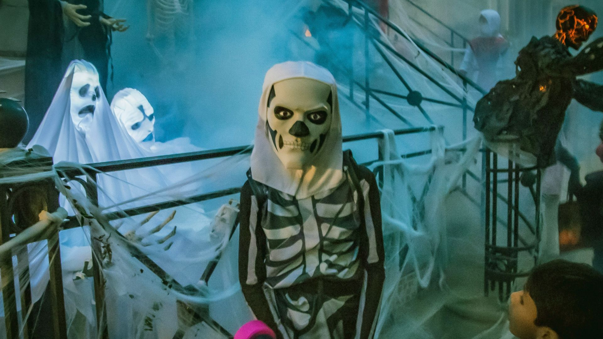 person in white mask standing beside white robot