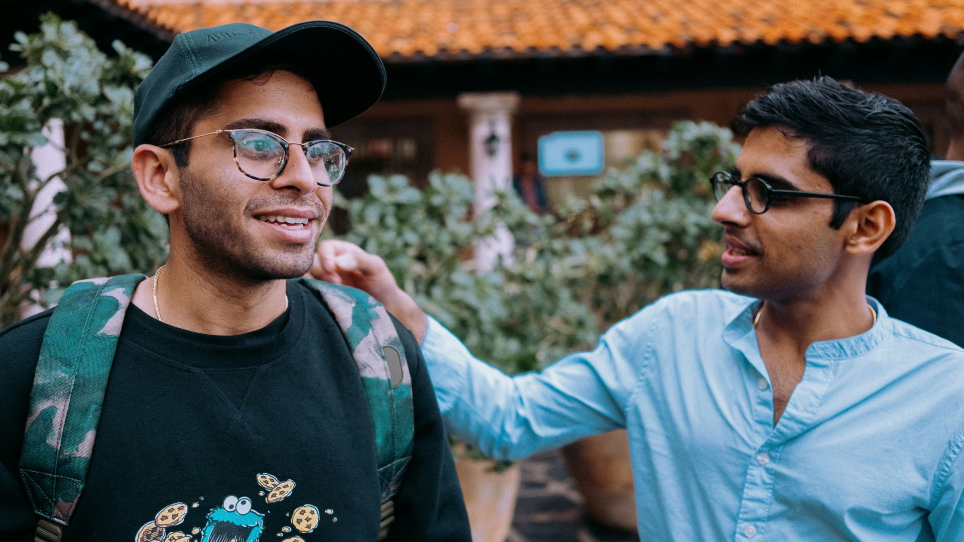 man in black crew neck shirt wearing black framed eyeglasses and black hat