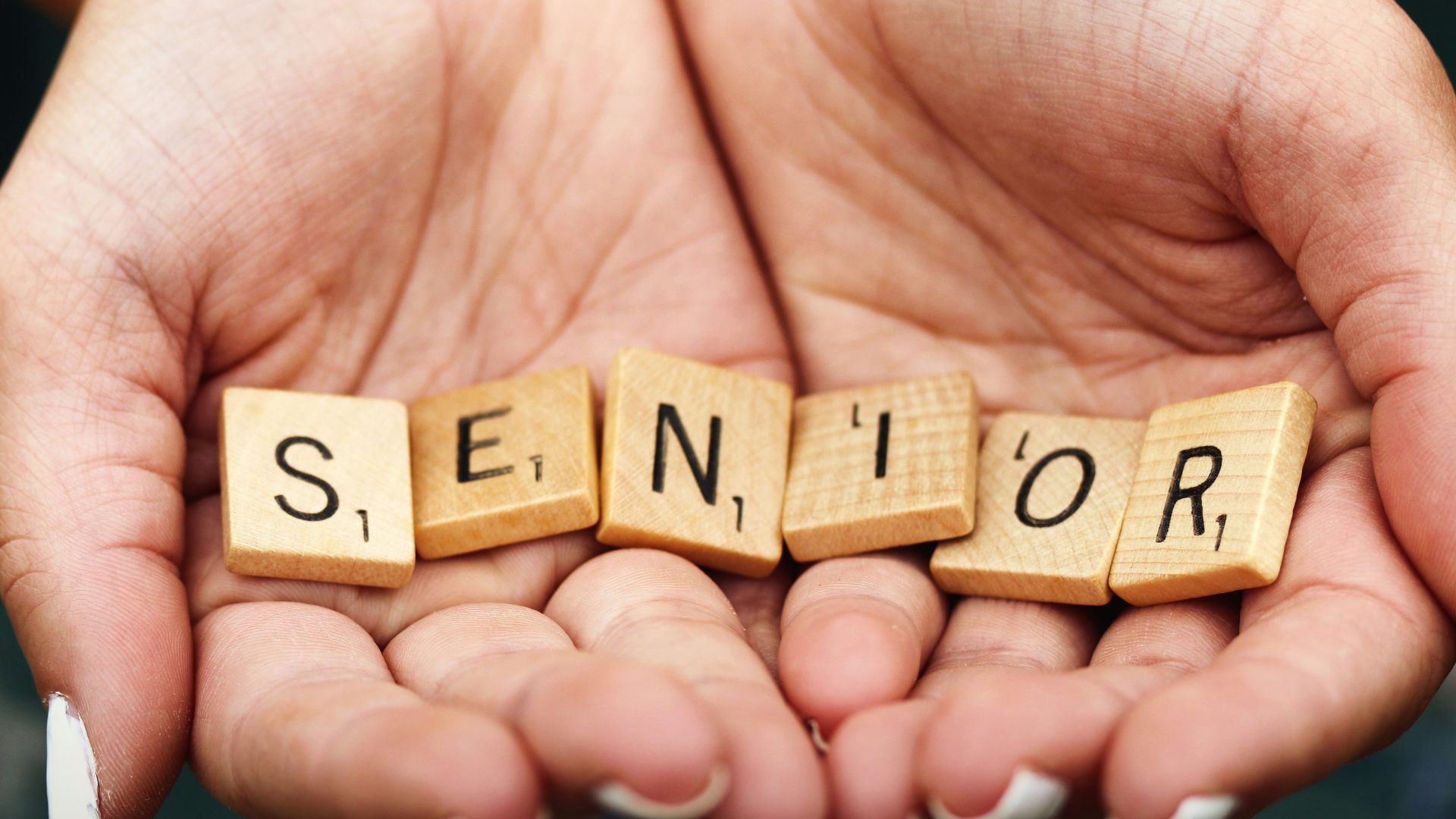Senior dice on person's palm