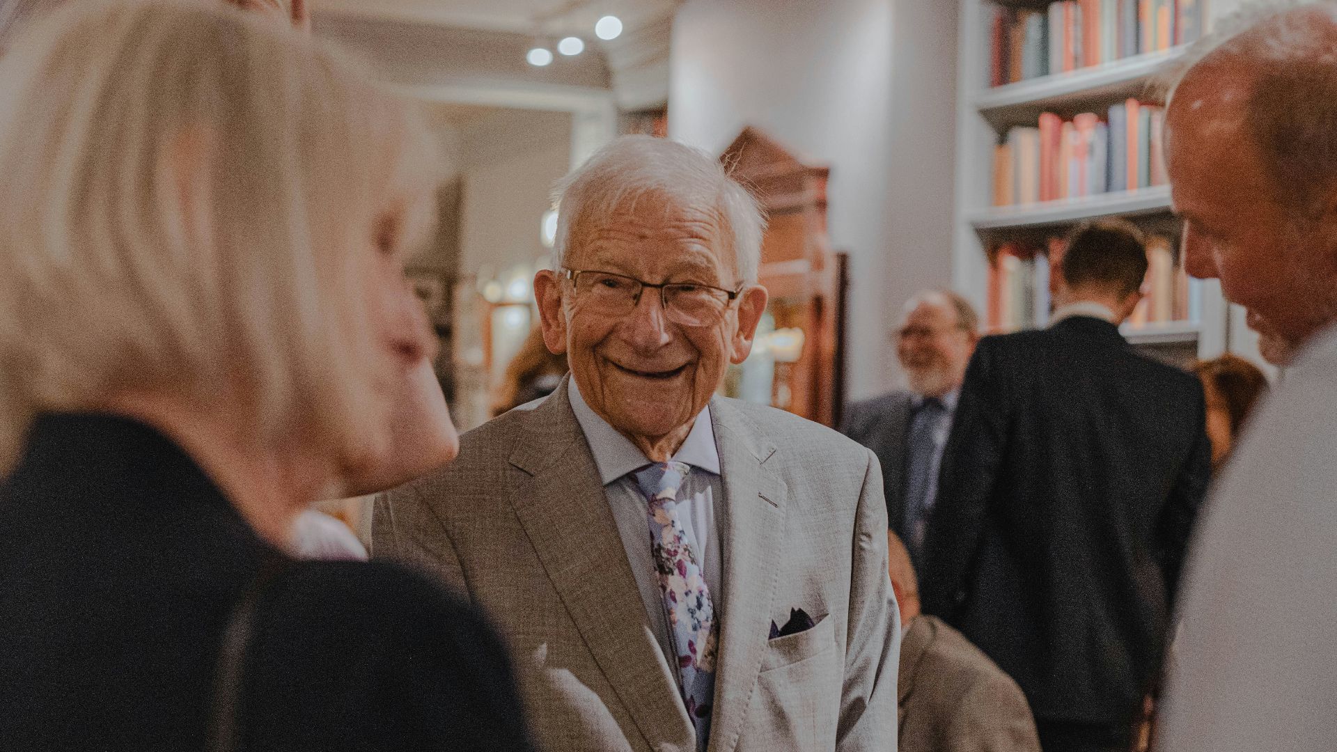 smiling man wearing suit standing beside man