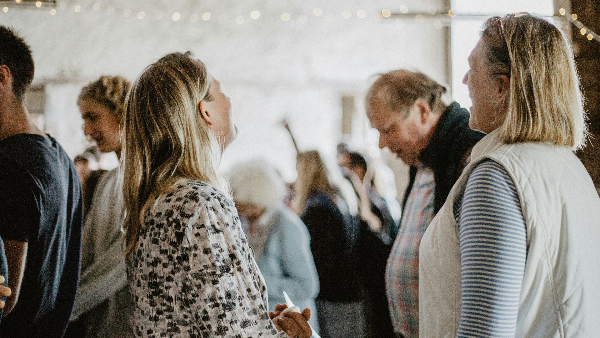 man in black suit jacket kissing woman in white and black leopard print coat