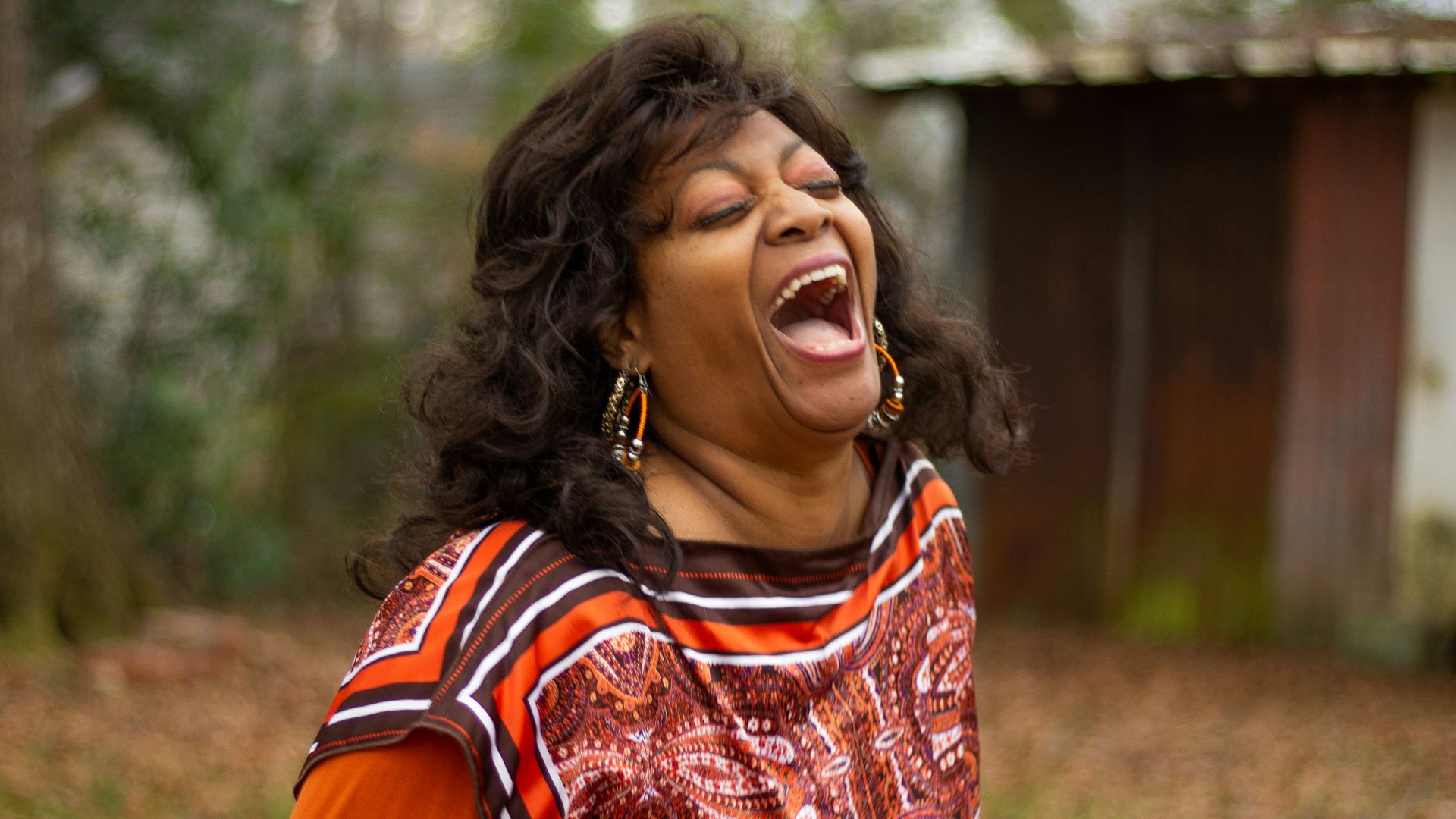 woman in orange and black dress smiling