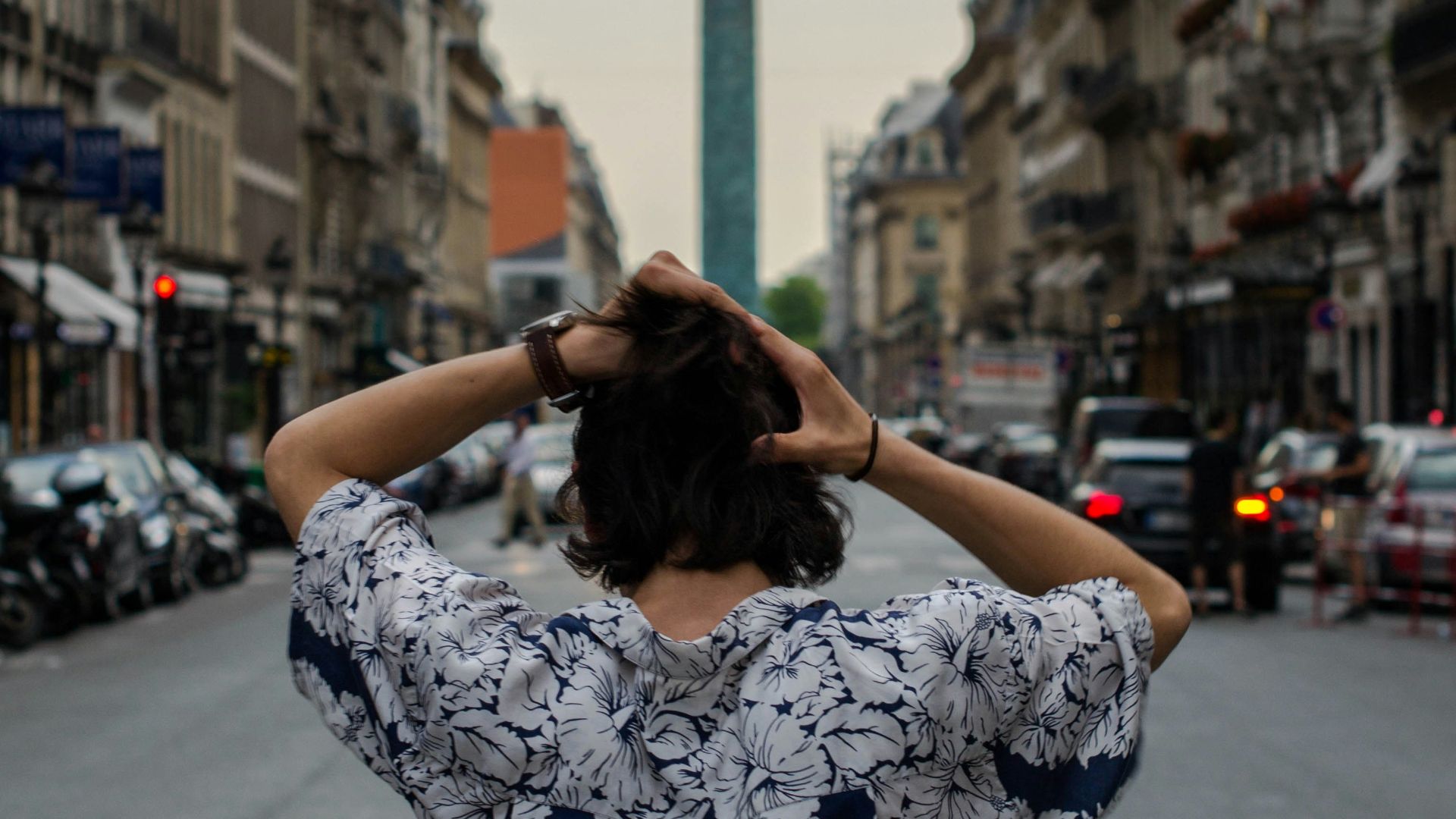 back view of man wearing floral top while fixing his hair