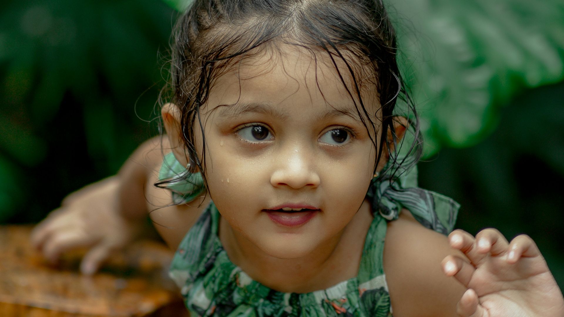 a little girl standing next to a tree stump