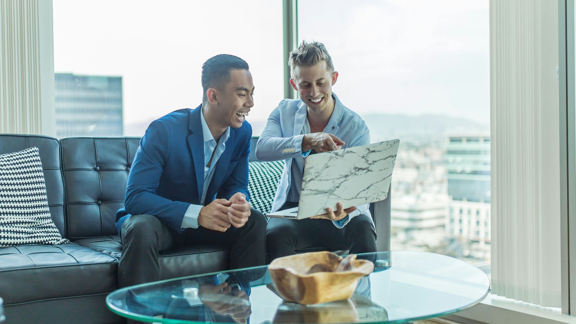 two men in suit sitting on sofa