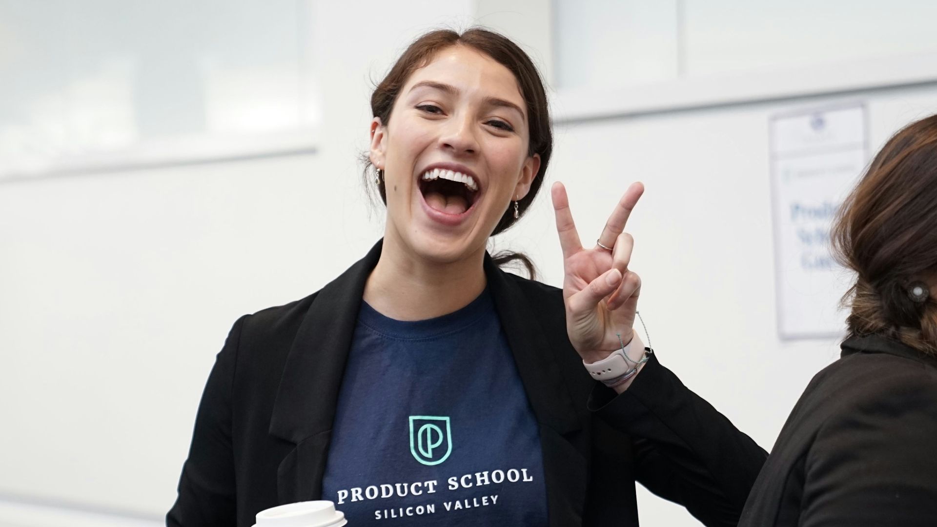 woman wearing suit making hand peace sign