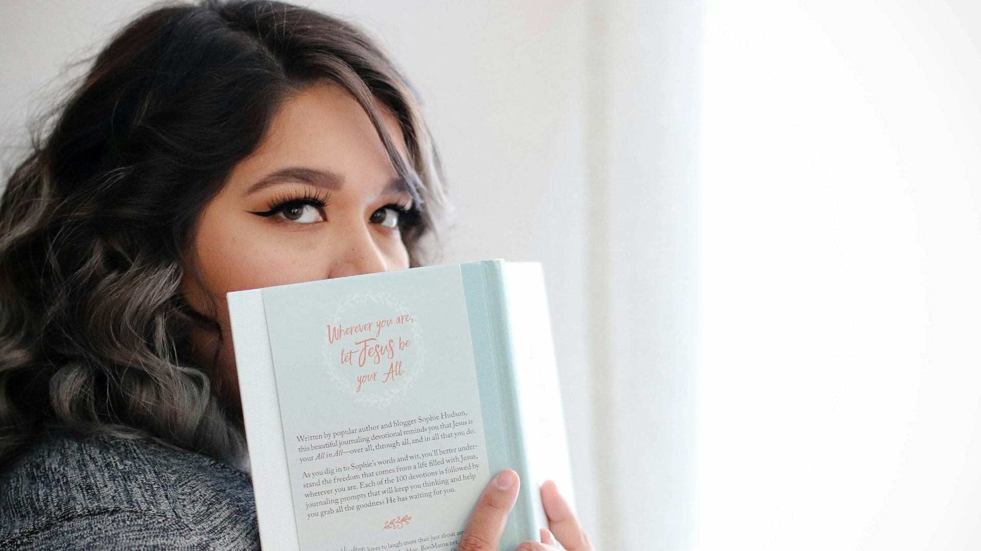 woman covering her face with book