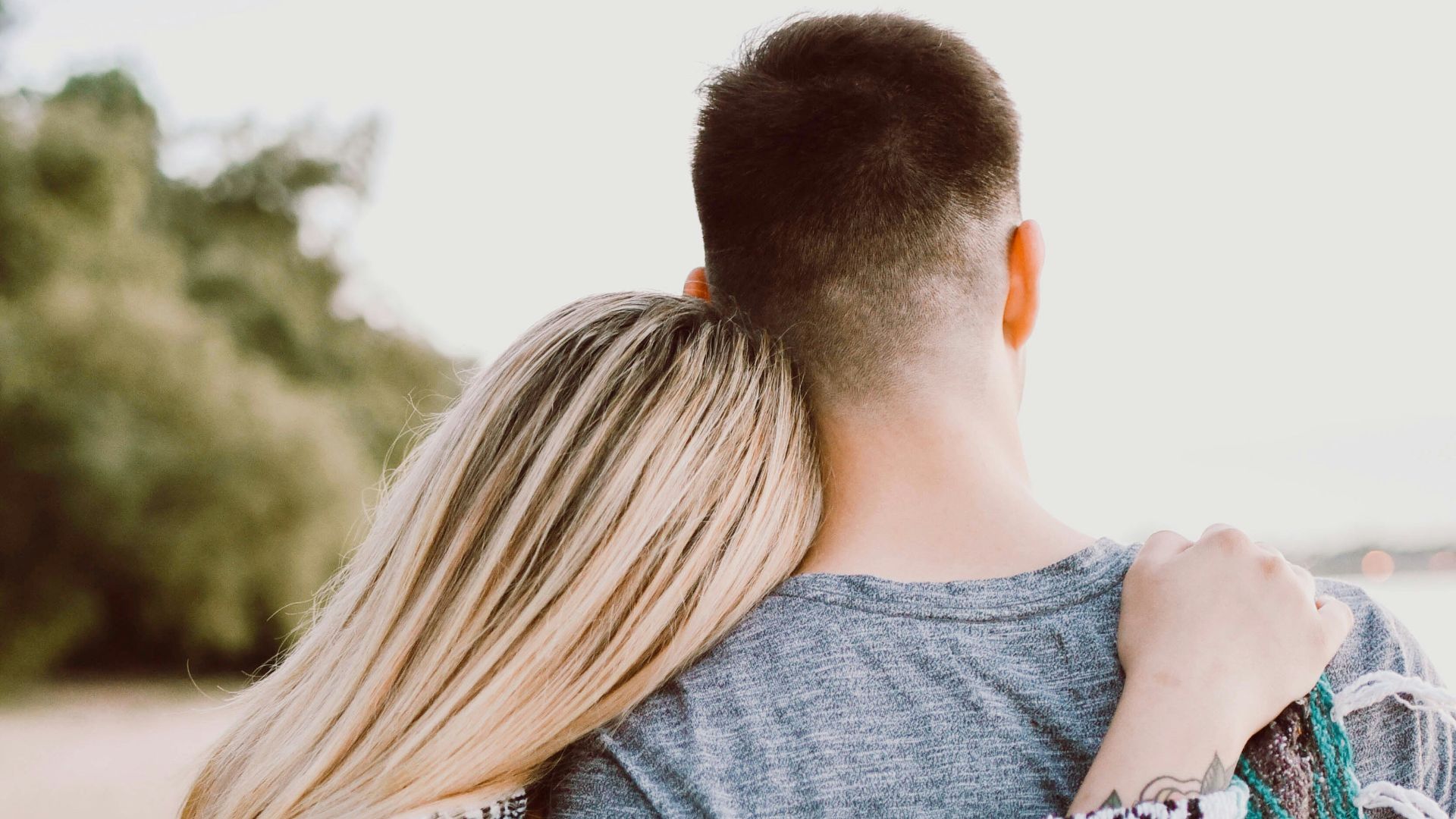 woman's hand on man's shoulder