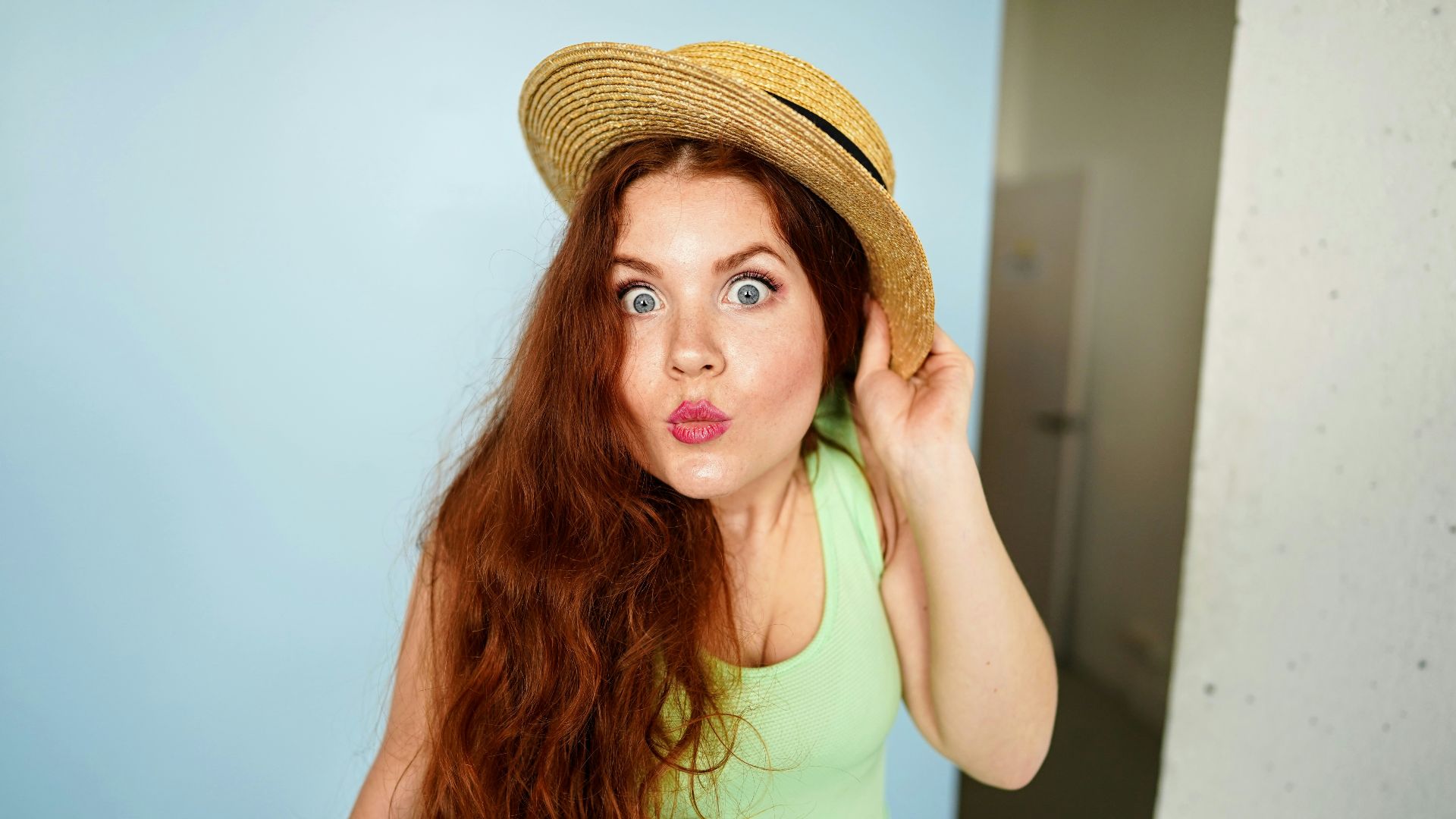 woman holding brown straw hat
