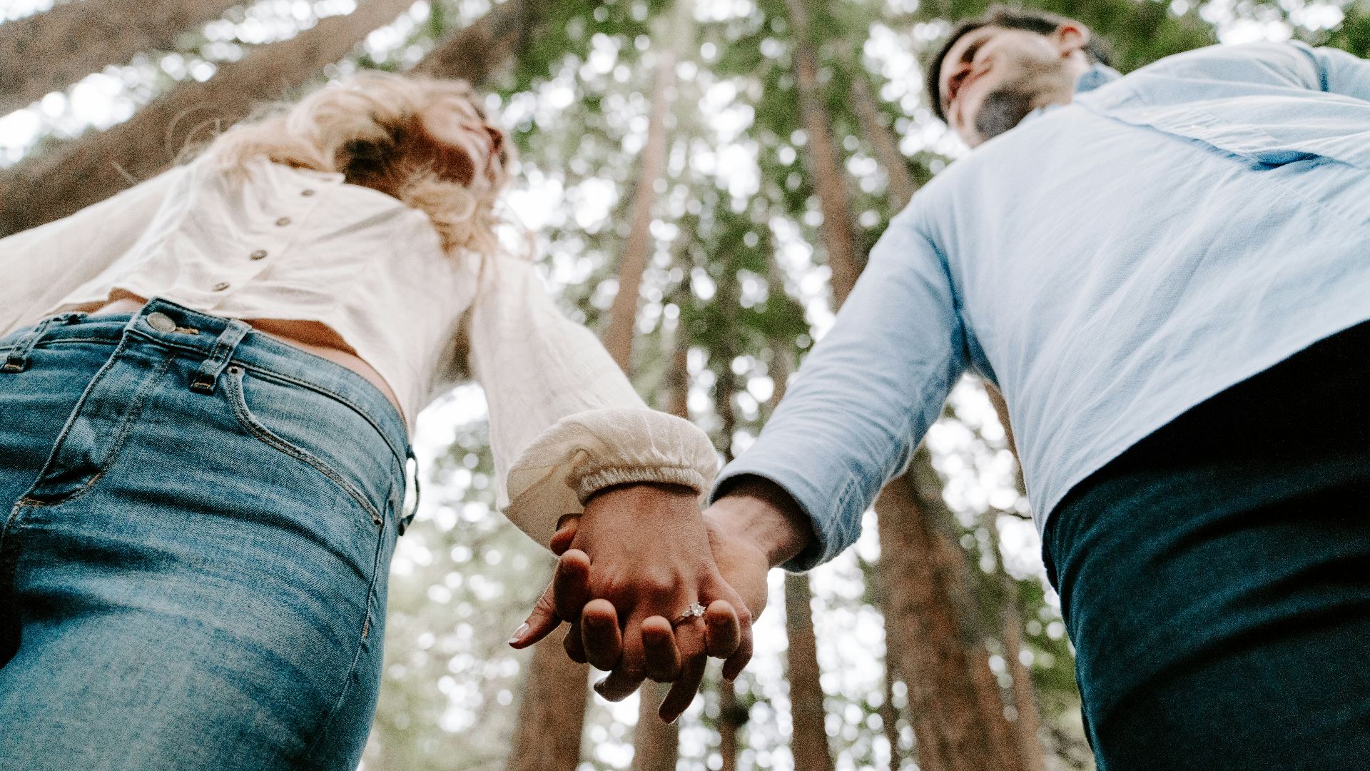 shalow focus photo of man and woman holding each others hands