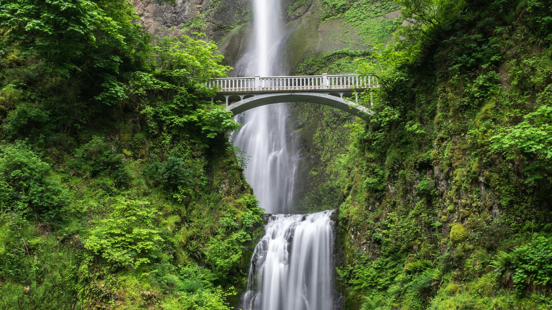 gray concrete bridge and waterfalls during daytime