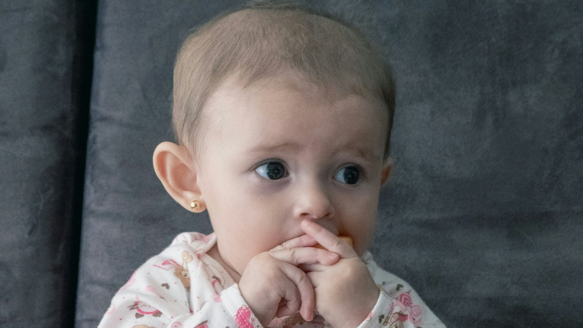 baby in white and pink onesie sitting on green and white ceramic plate