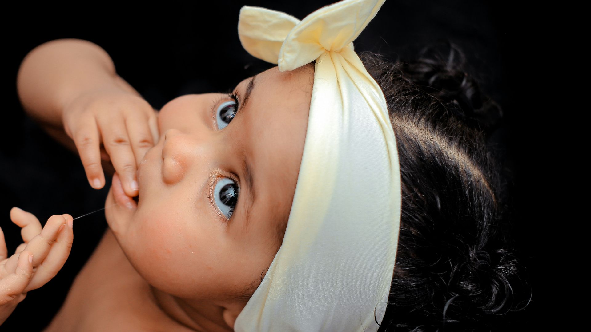 toddler wearing yellow ribbon close-up photography