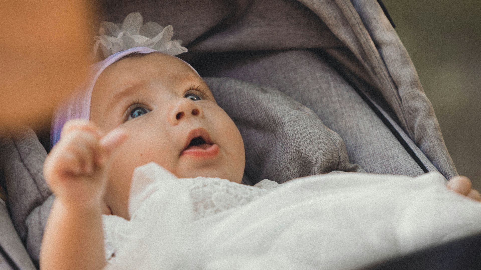 a baby in a stroller looking up at something