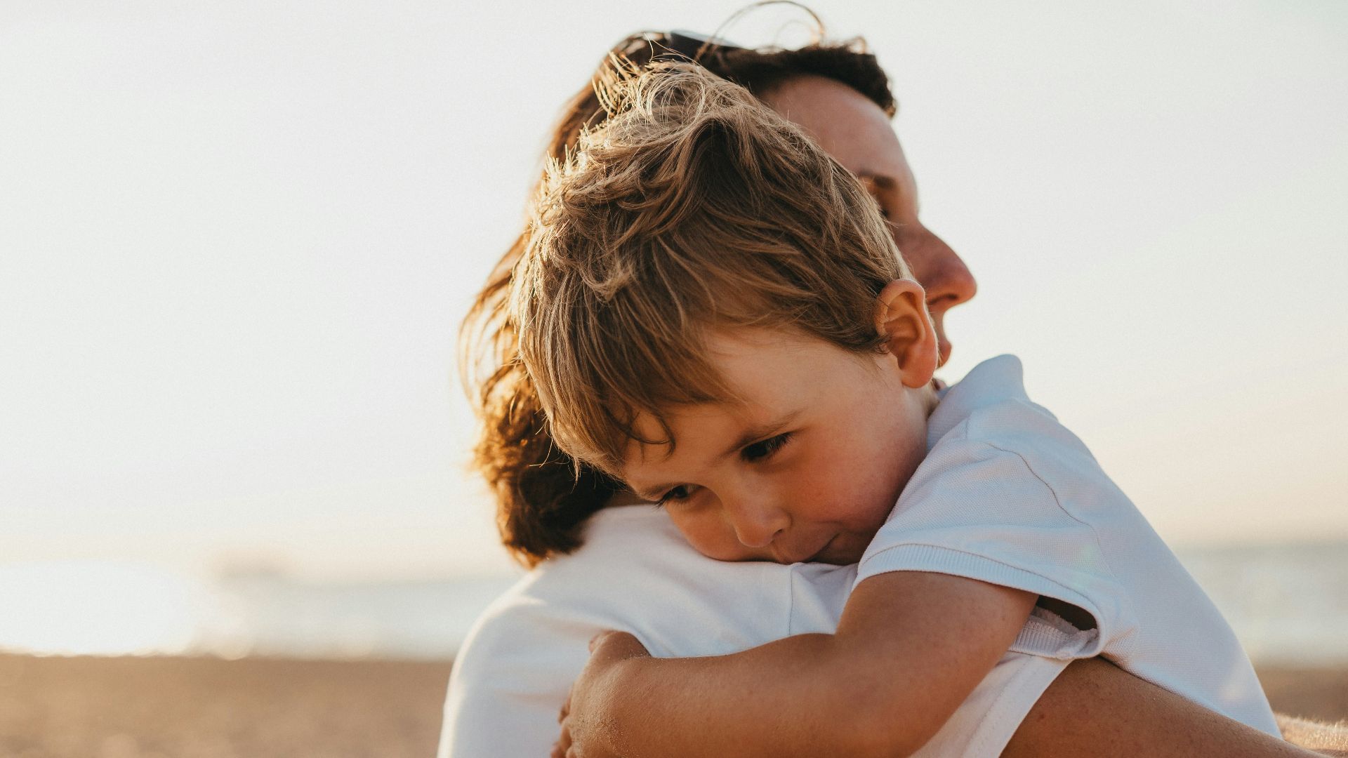 boy hugging woman during daytime