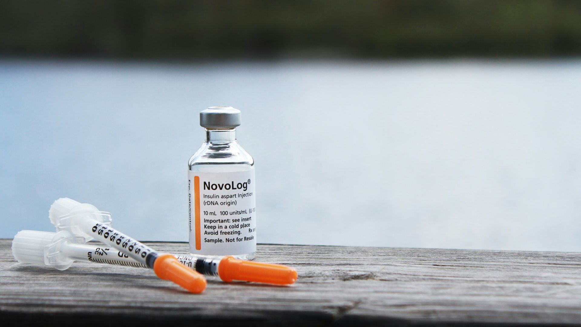 orange and white plastic bottle on brown wooden table