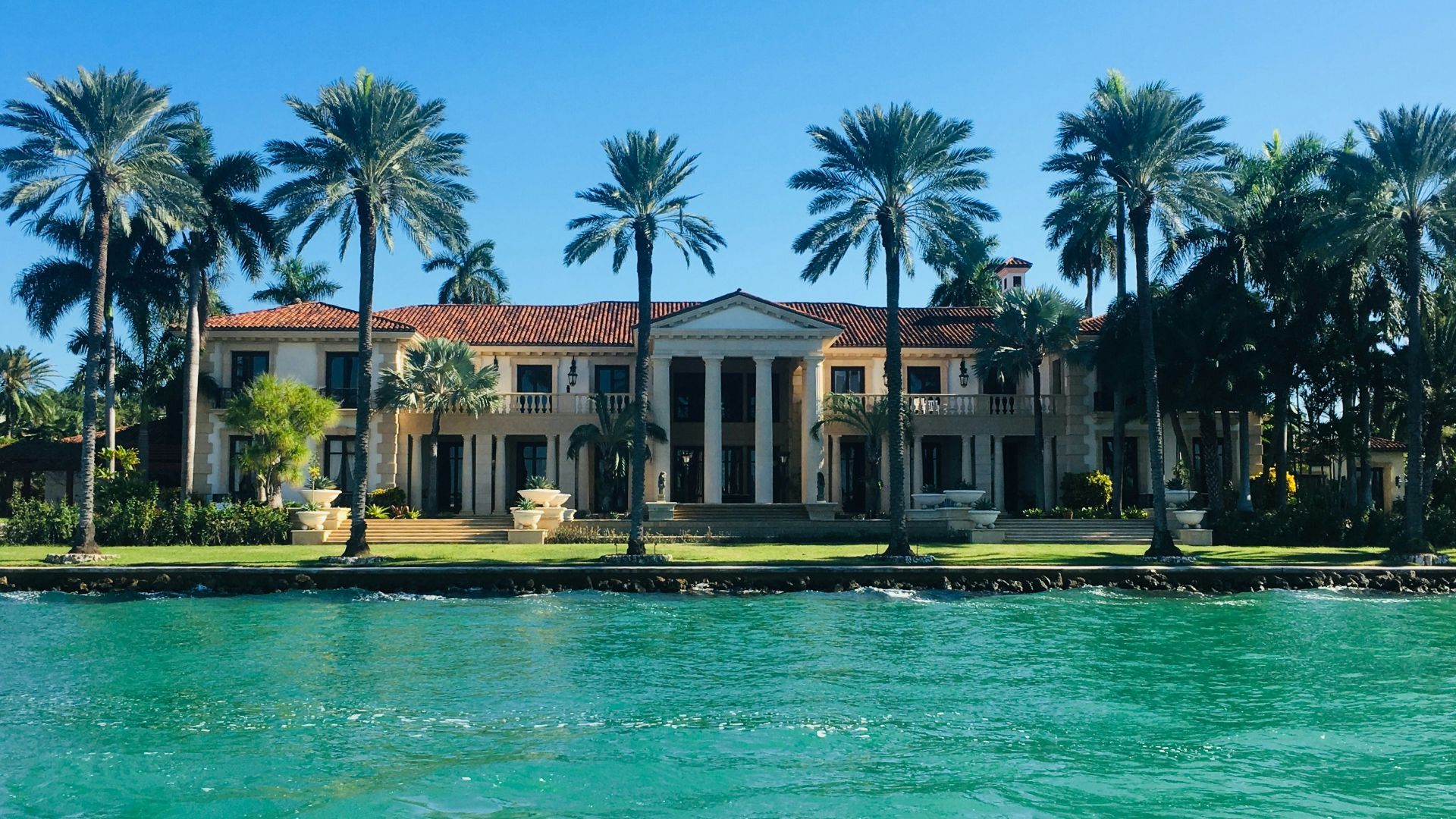 brown and white concrete house near body of water ahead