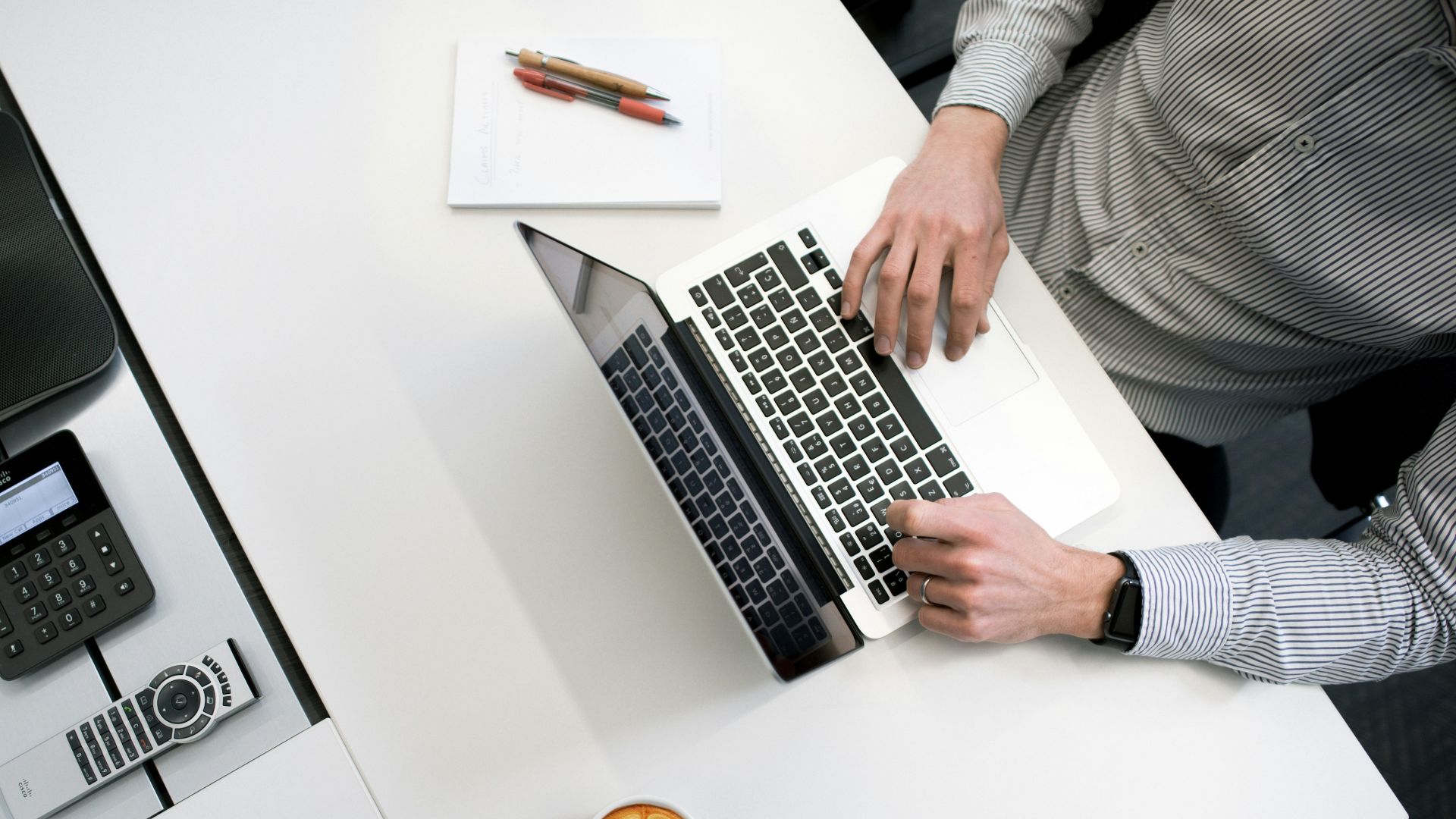 person using laptop on white wooden table