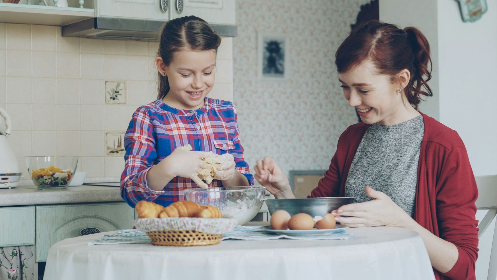 Mother and daughter baking happily in the kitchen.