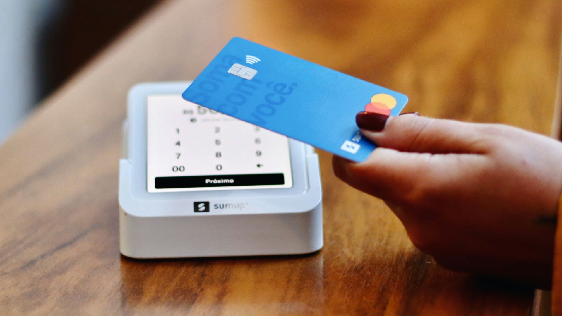 a person holding a credit card in front of a machine