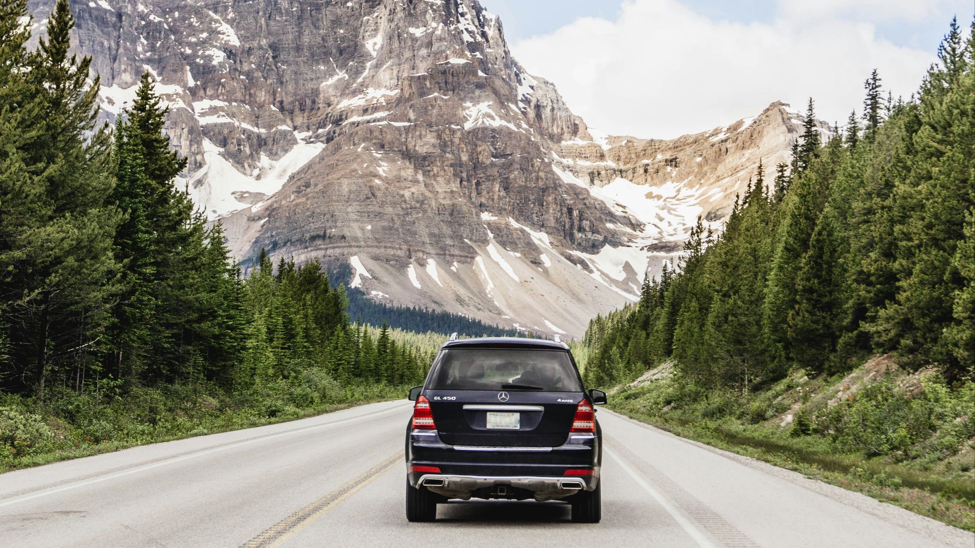 black car on road near mountain range