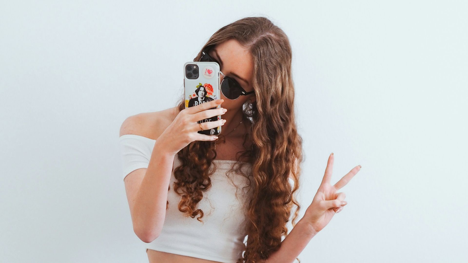 woman in pink tank top and blue denim jeans sitting on yellow chair