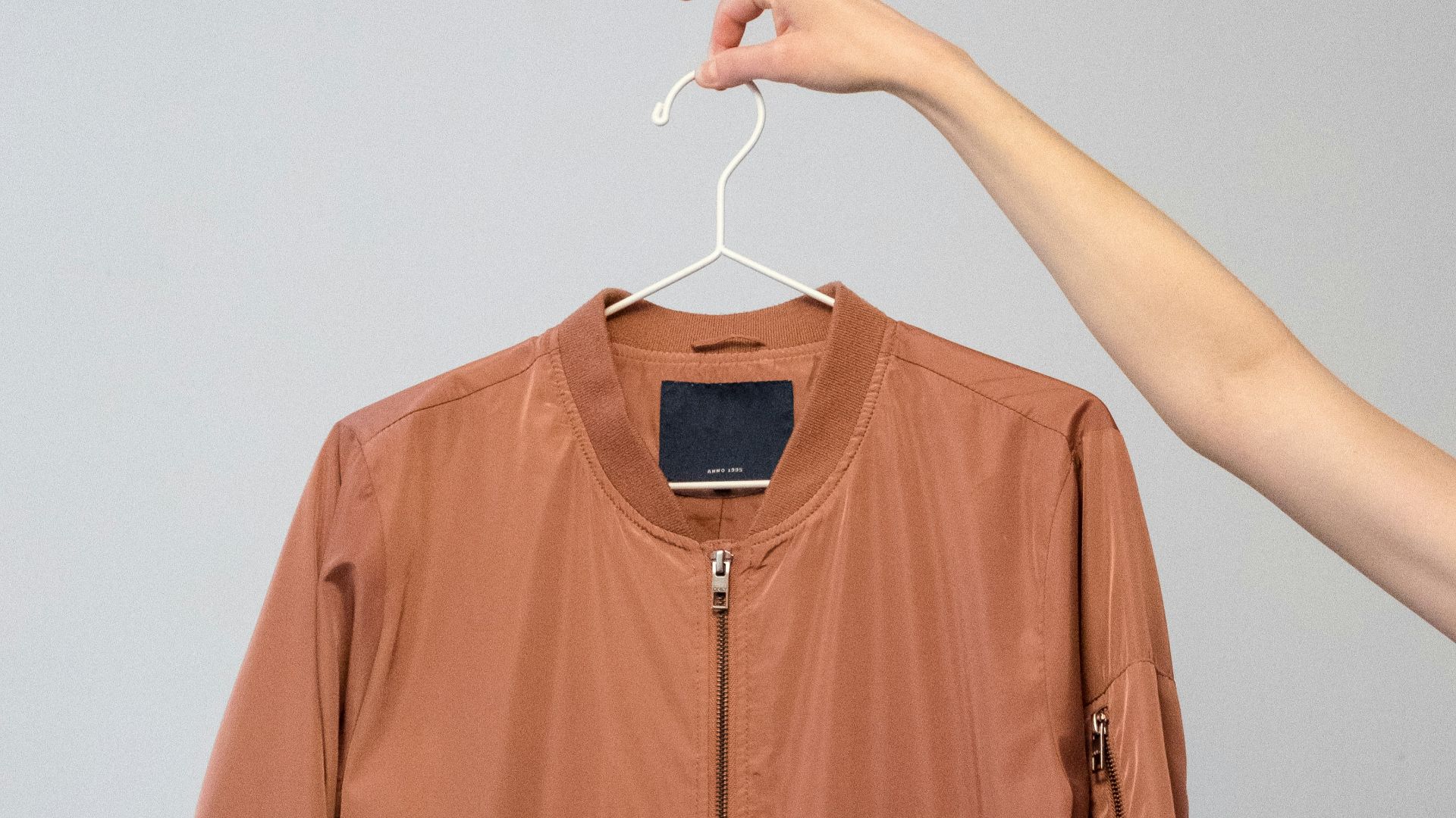 brown long sleeve shirt on white clothes hanger
