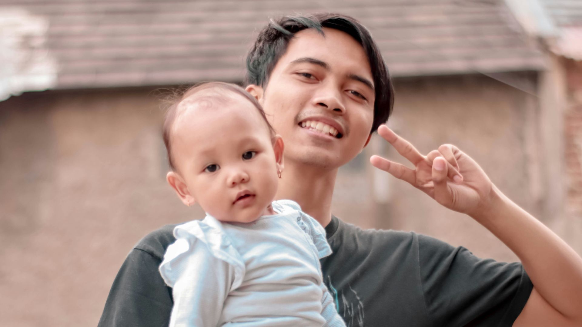 smiling man carrying baby