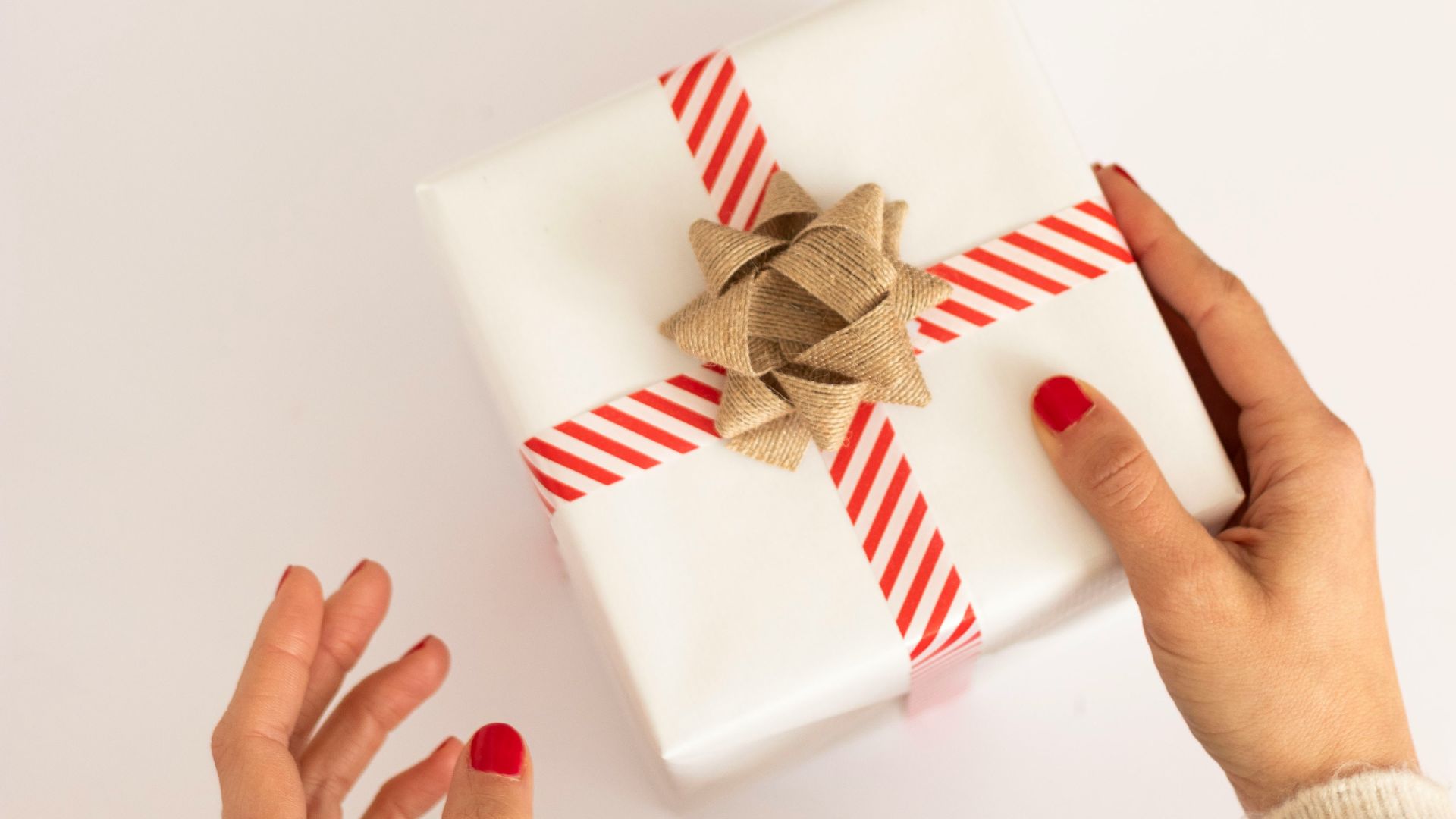 person holding white and red gift box