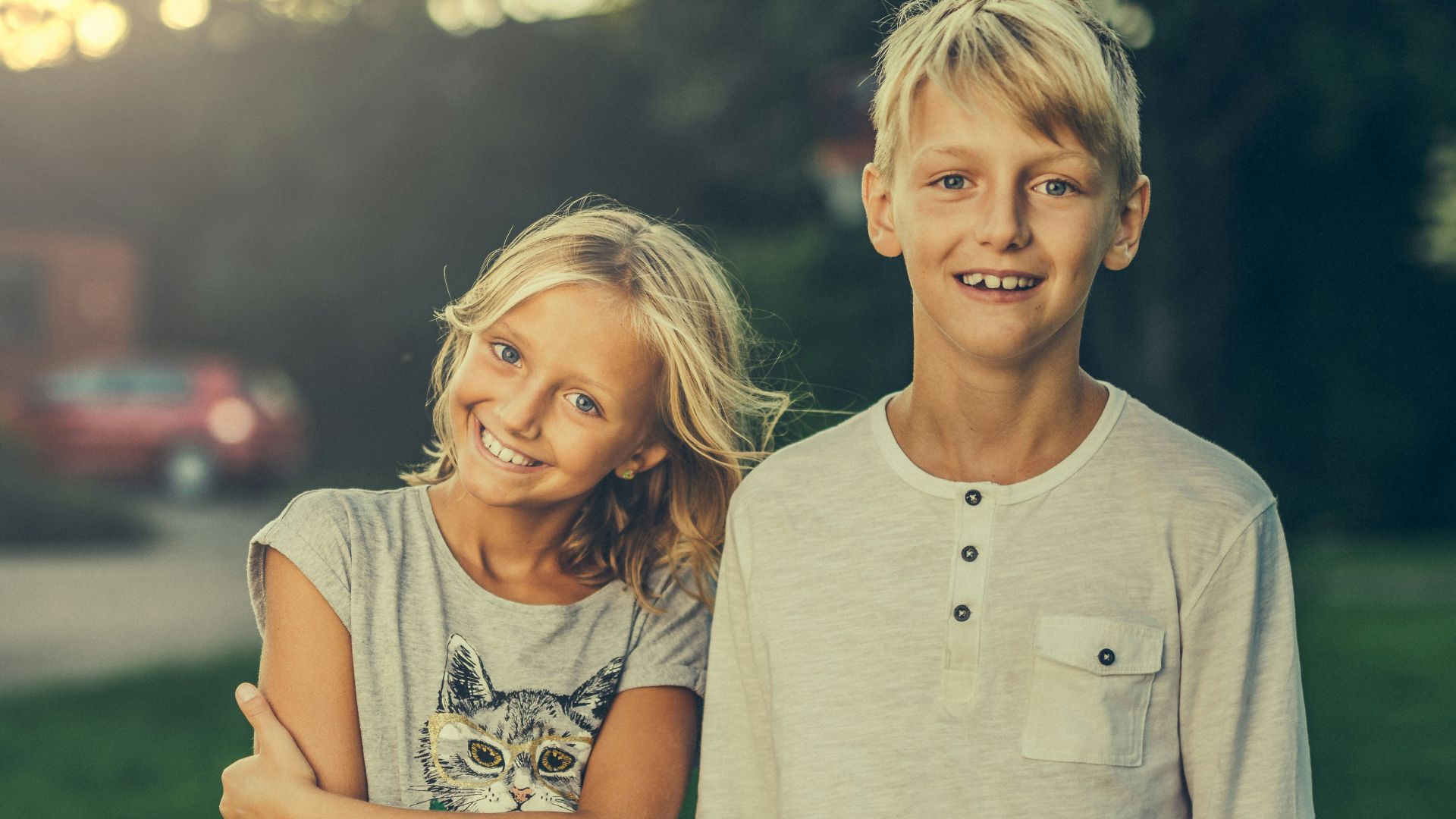 girl and boy standing on green grass field