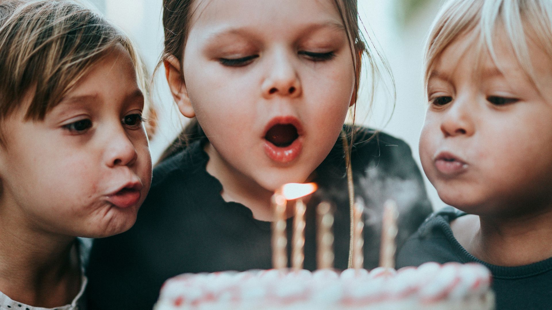 boy and girl blowing candles