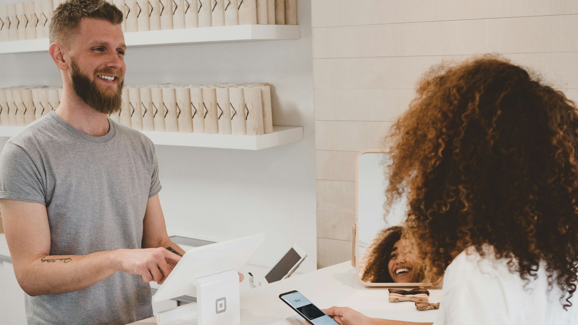 man in grey crew-neck t-shirt smiling to woman on counter