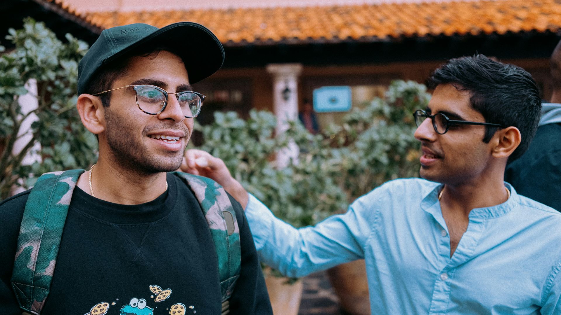 man in black crew neck shirt wearing black framed eyeglasses and black hat