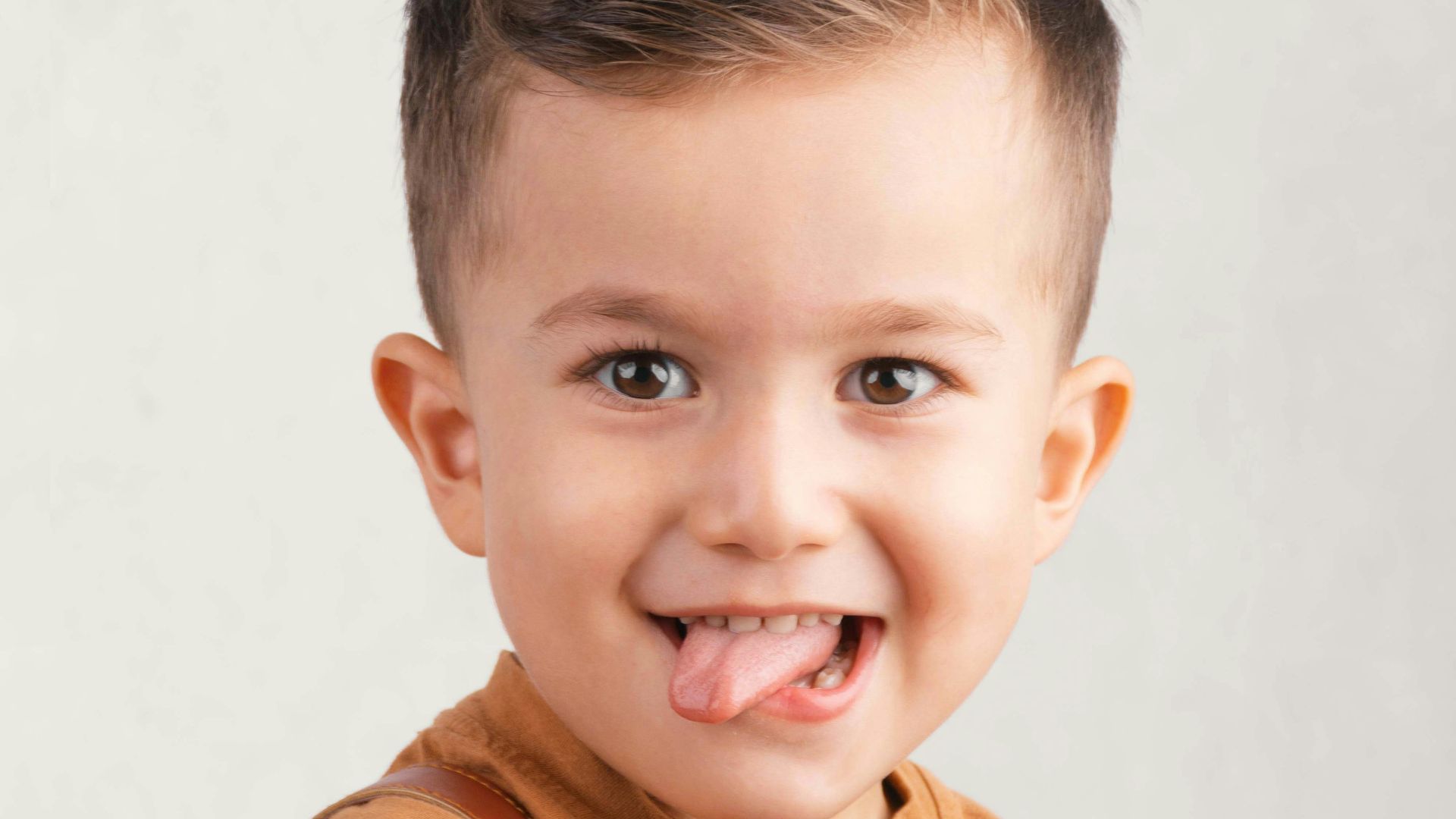 A young boy sticking his tongue out playfully.