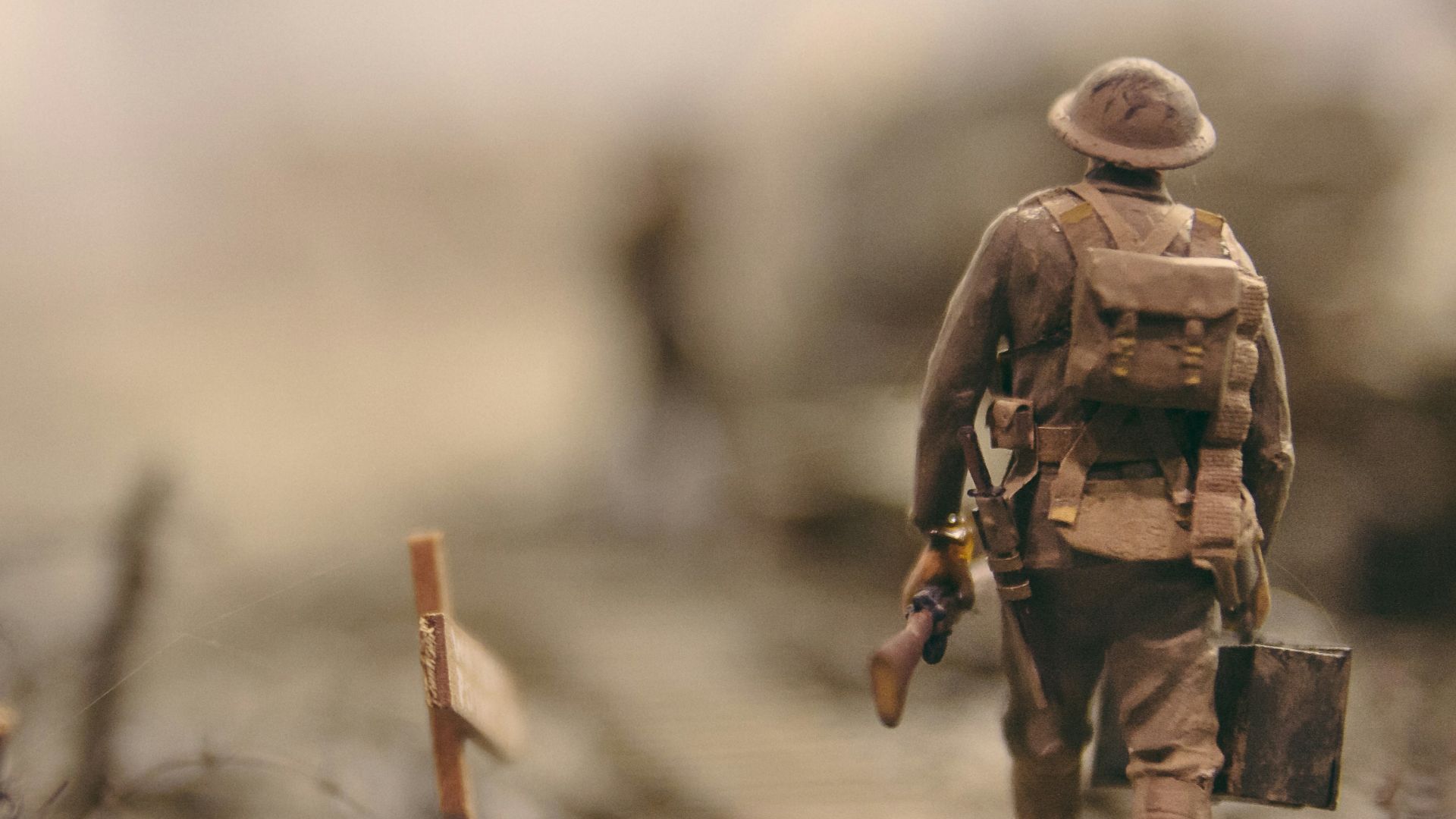 soldier walking on wooden pathway surrounded with barbwire selective focus photography