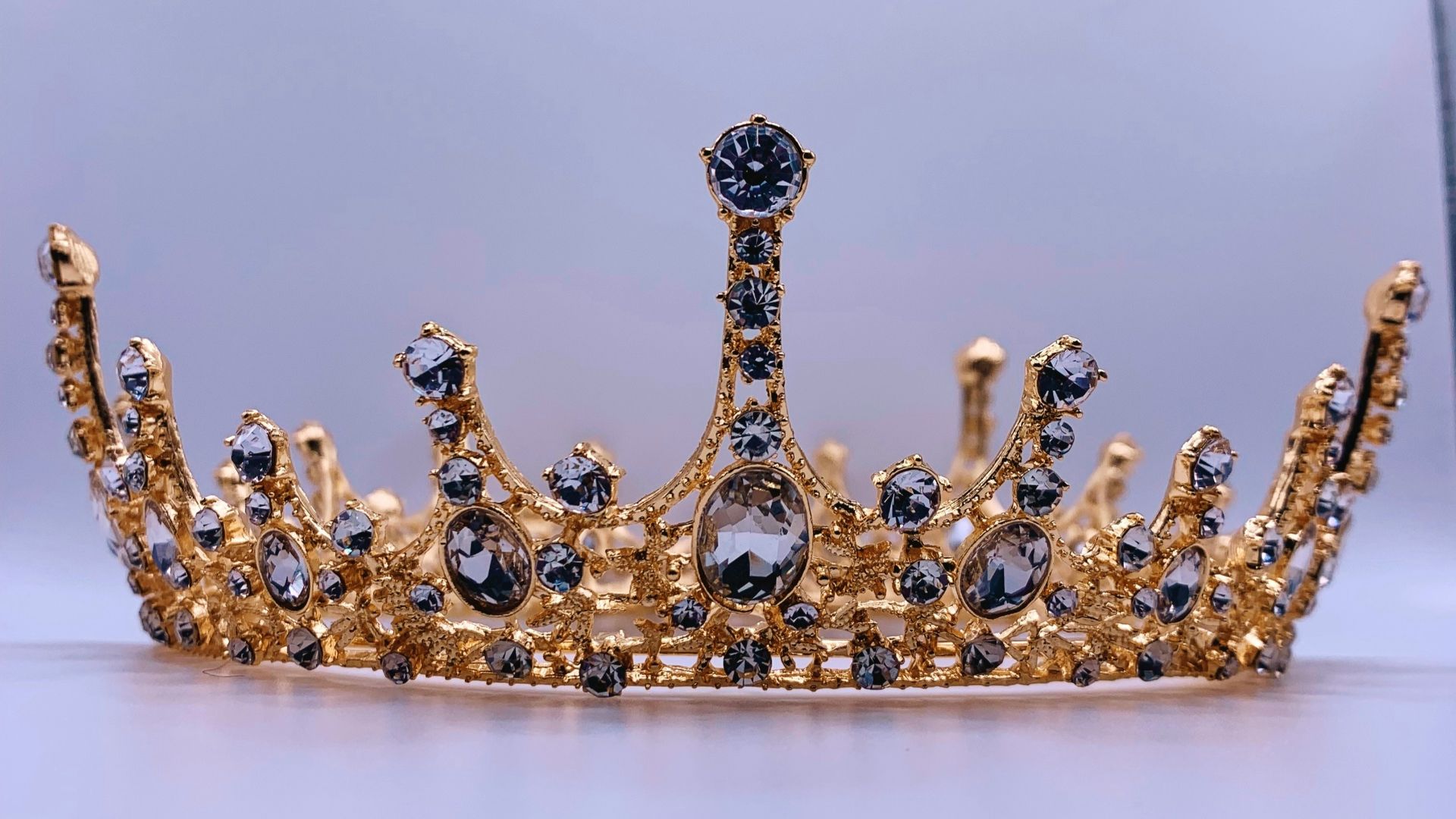 a gold crown with black and white stones
