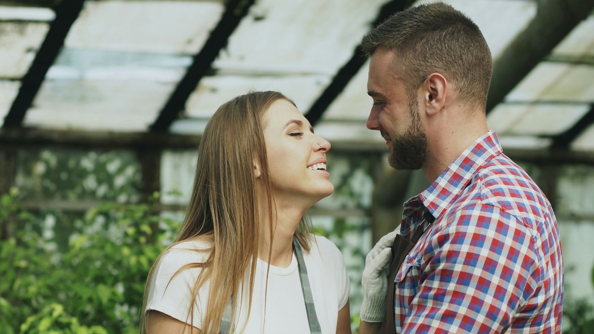 Couple embracing in a greenhouse with plants