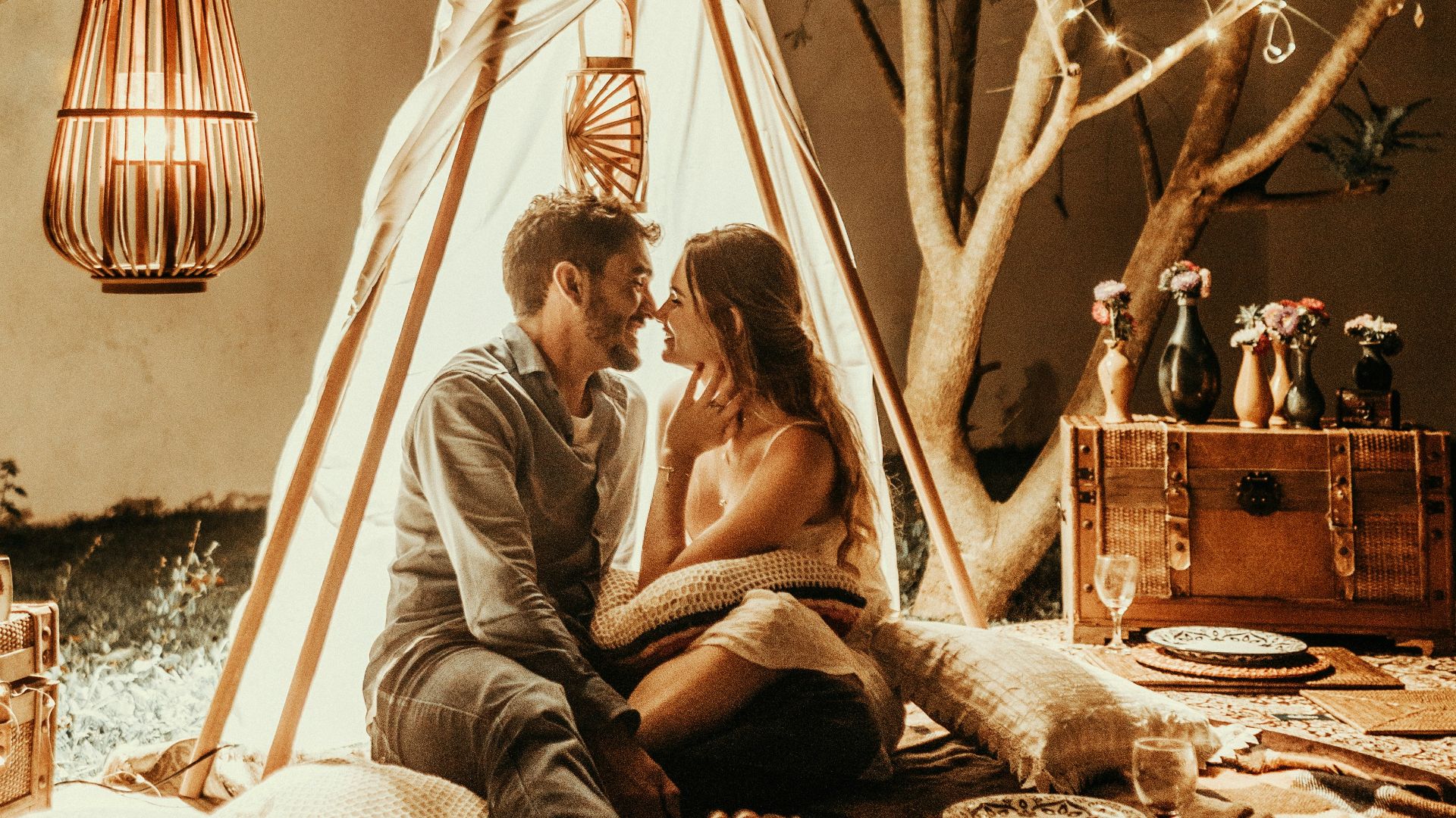 smiling man and woman inside tipi tent