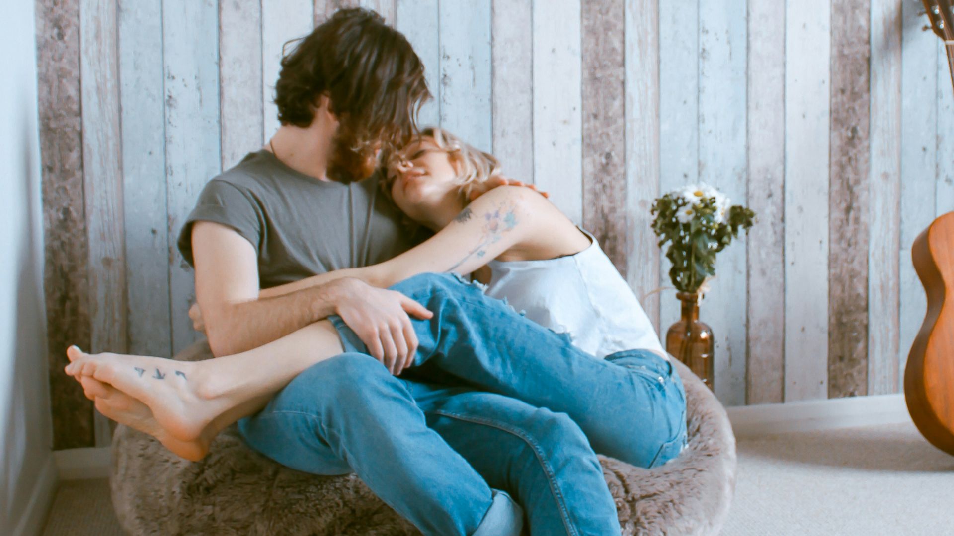 man and woman sitting on gray beanbag