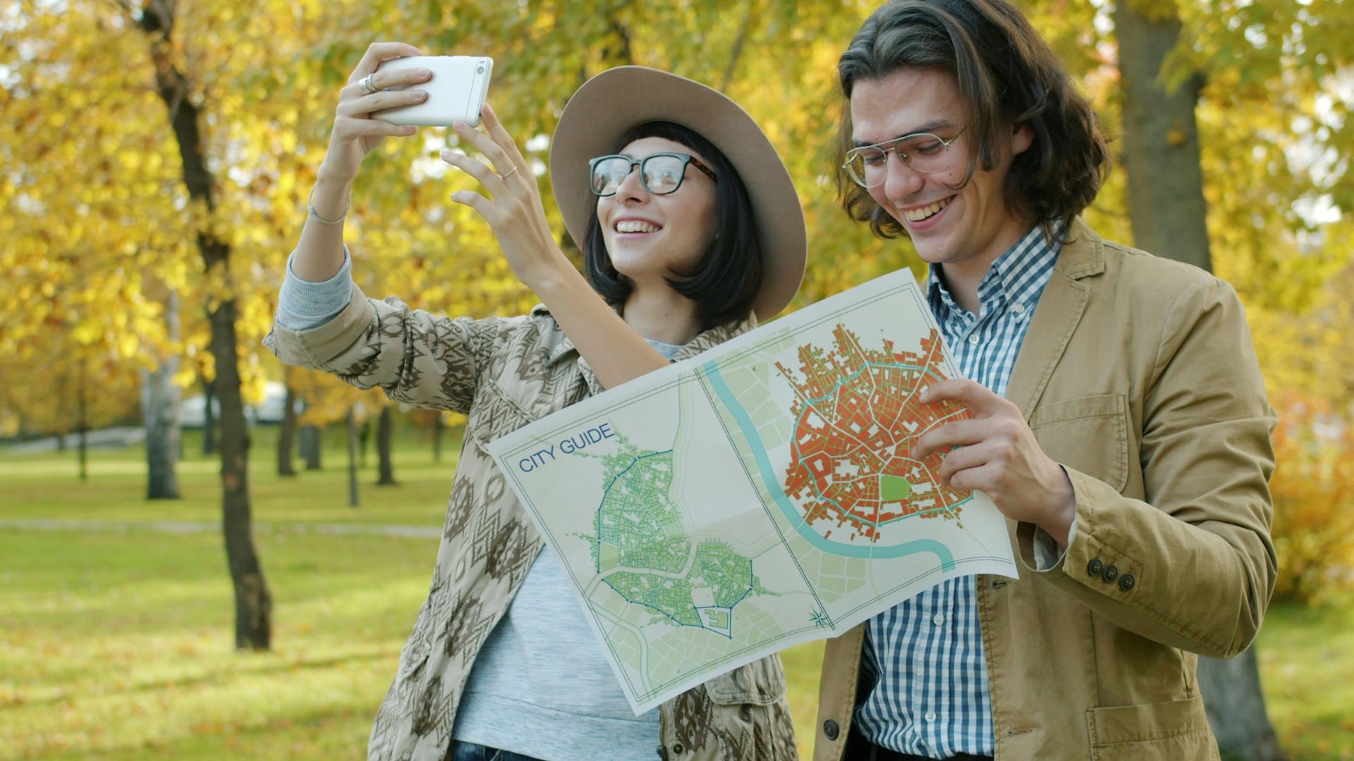 Couple taking a selfie with a map in park