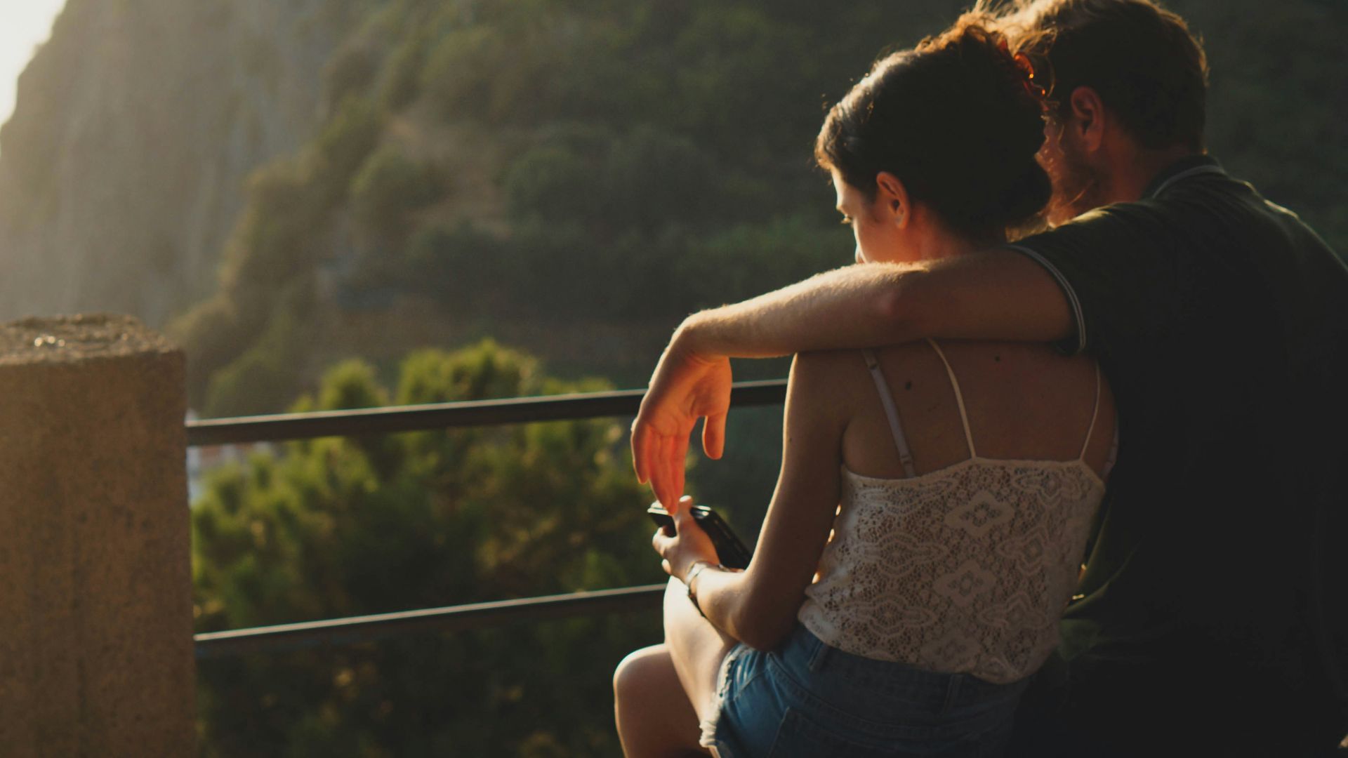 man and woman sitting on concrete surface