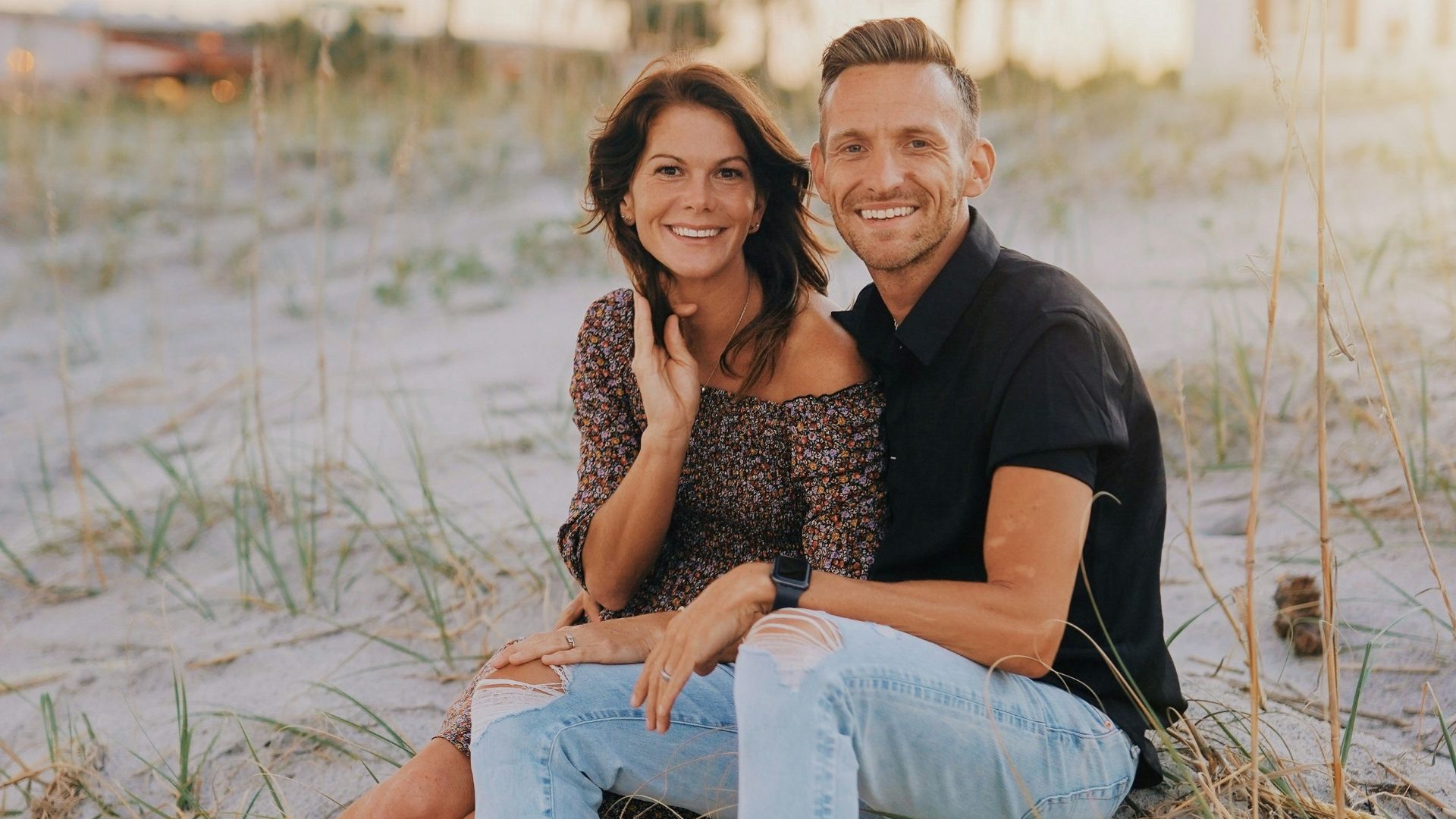 a man and woman sitting on a beach