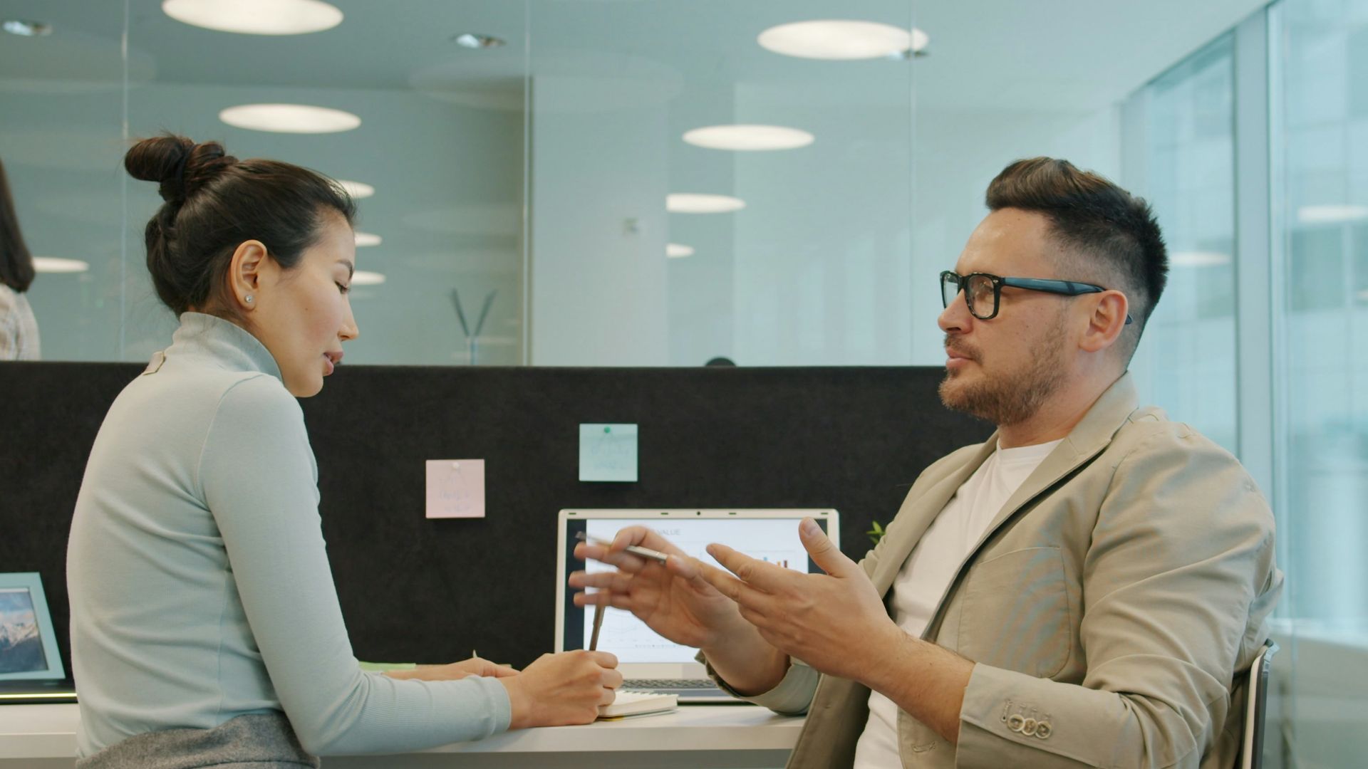 Two colleagues discussing work in a modern office.